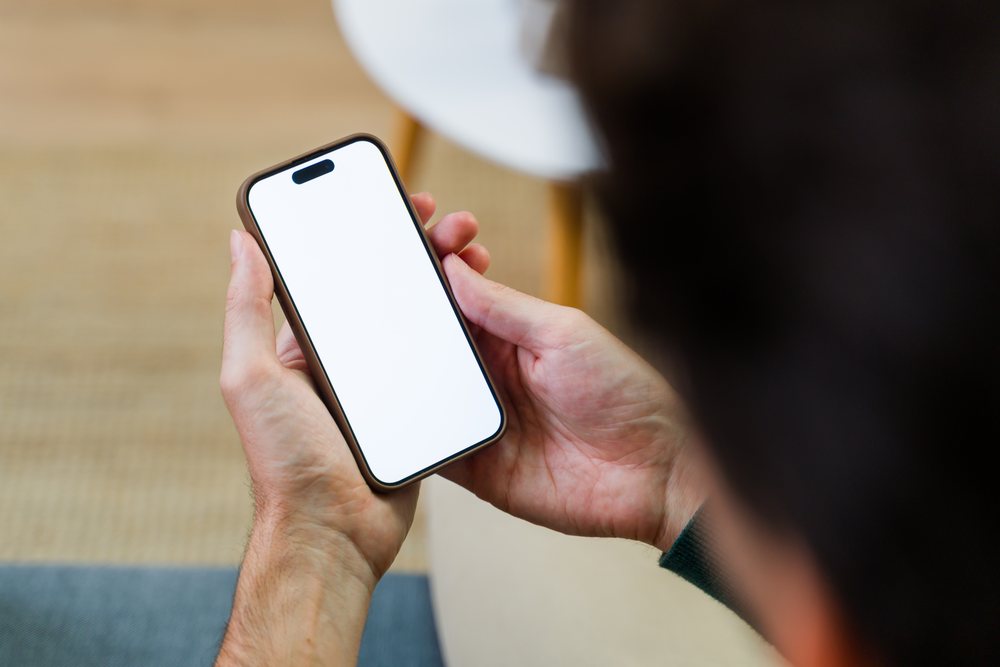 Person holding smartphone with blank white screen setting