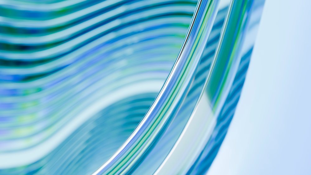 Abstract curved glass waves with blue and green reflections