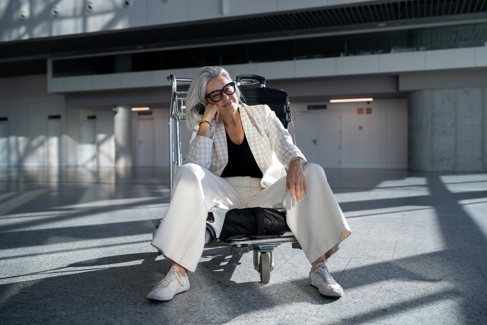 White woman resting on luggage cart