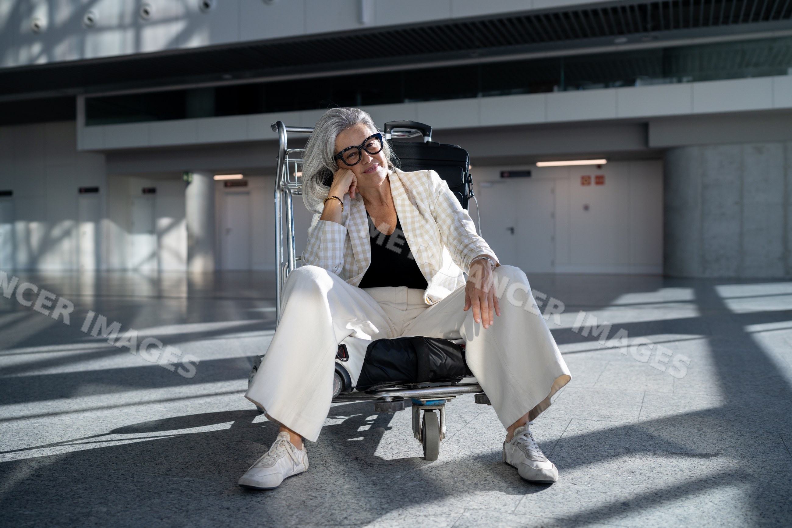 White woman resting on luggage cart