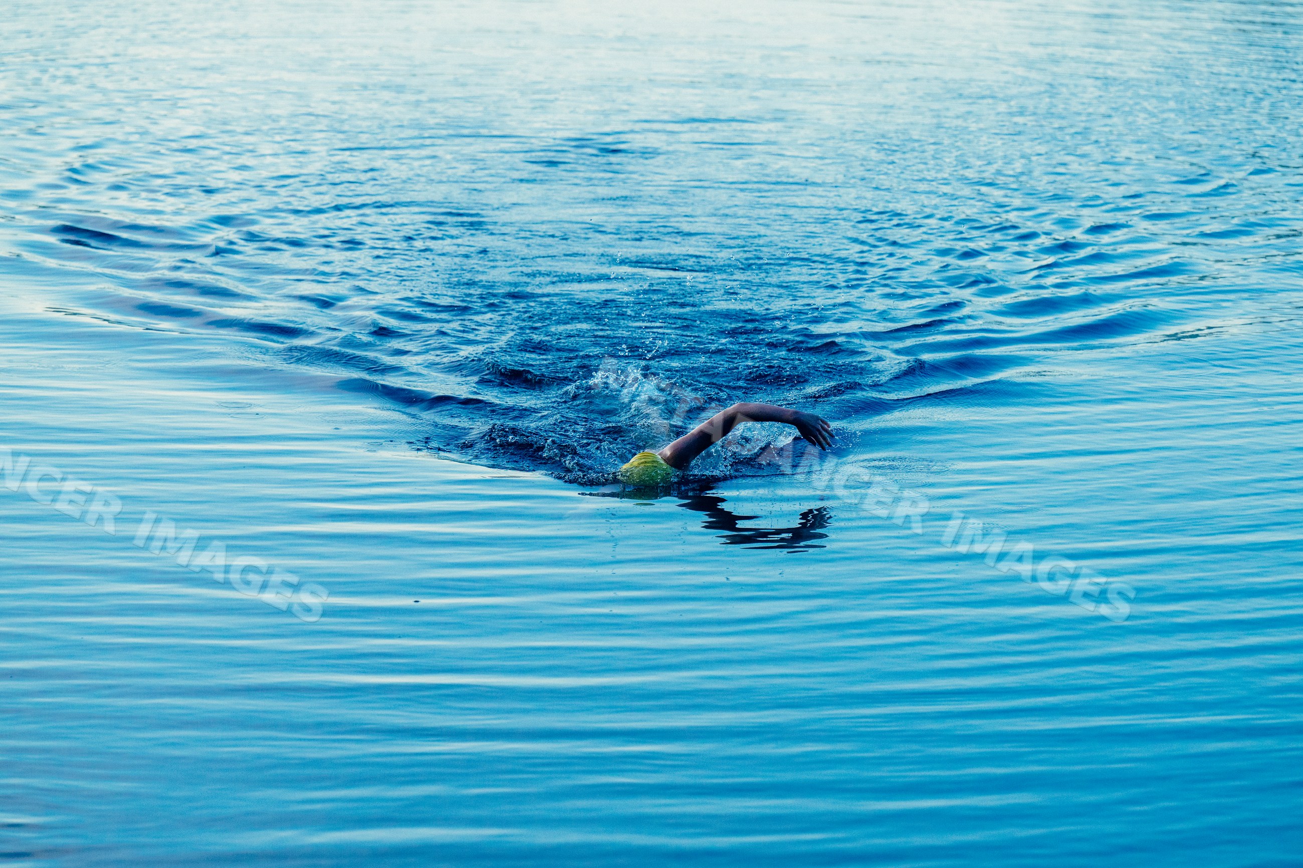 White swimmer performing freestyle stroke in open water