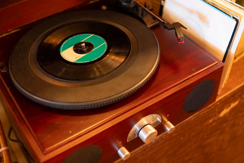 A vintage wooden turntable playing vinyl records with retro music