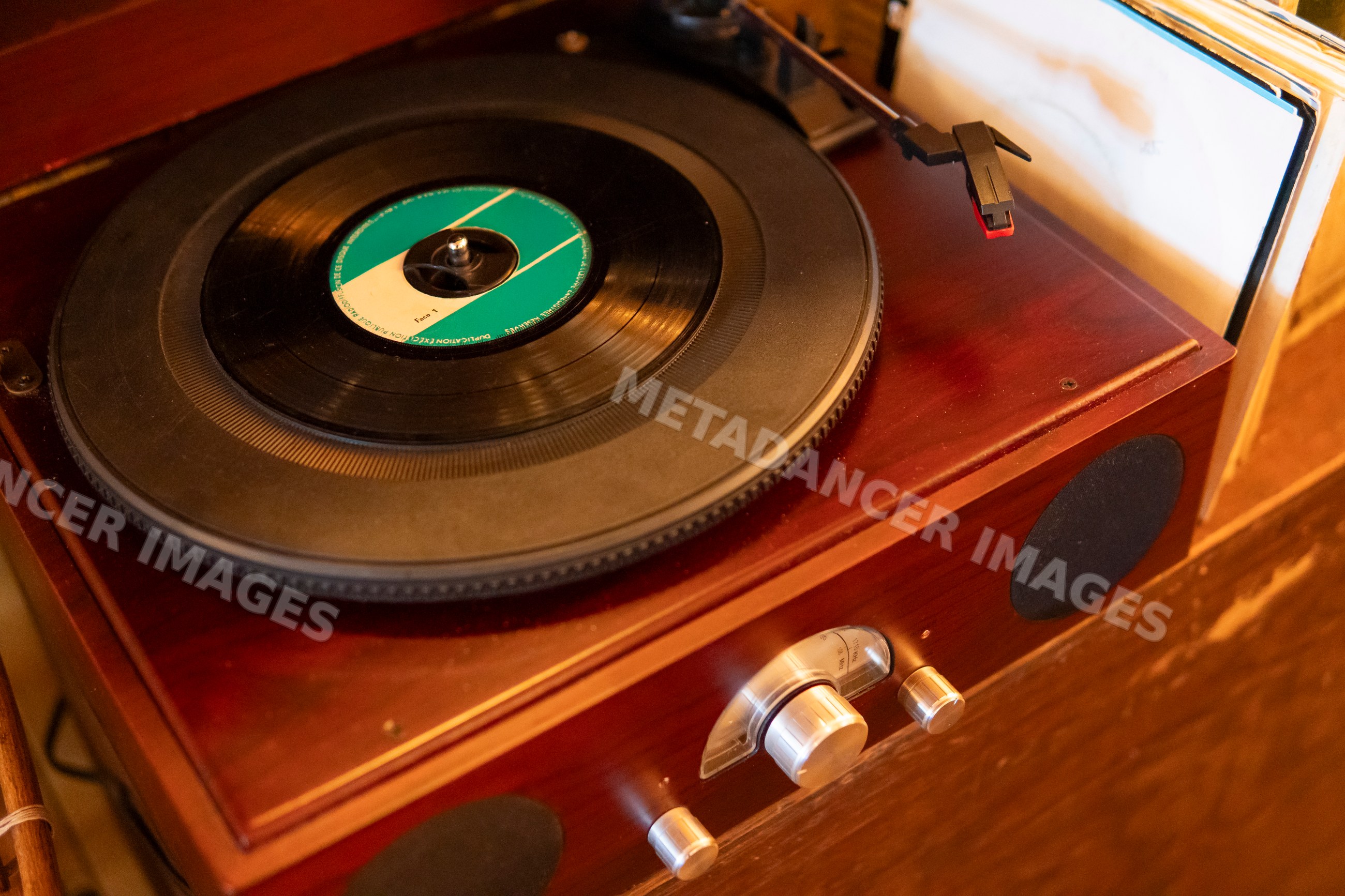 A vintage wooden turntable playing vinyl records with retro music