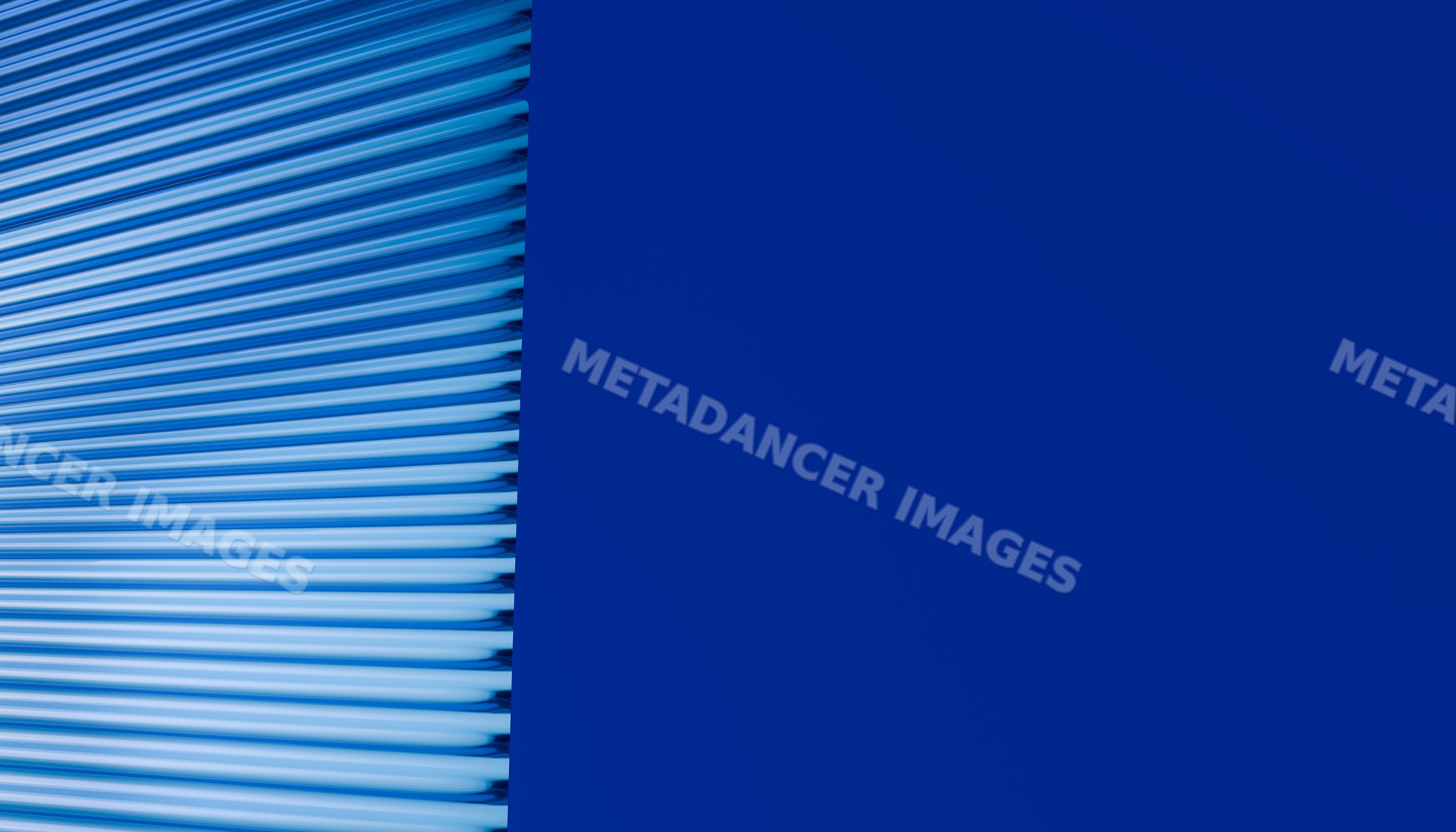 Blue metal roller shutter door with horizontal ridges and solid wall