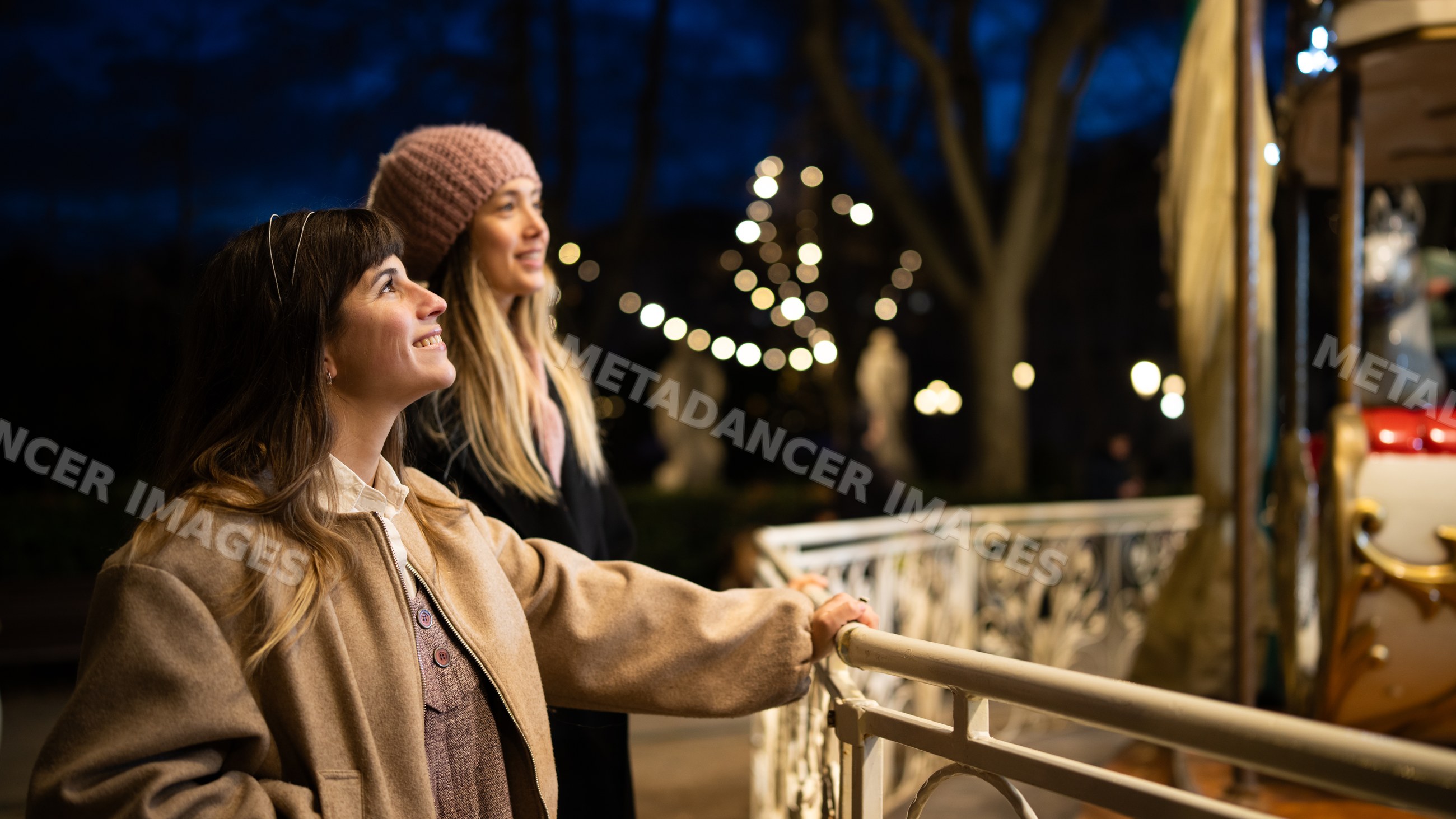 Two white women enjoy festive lights