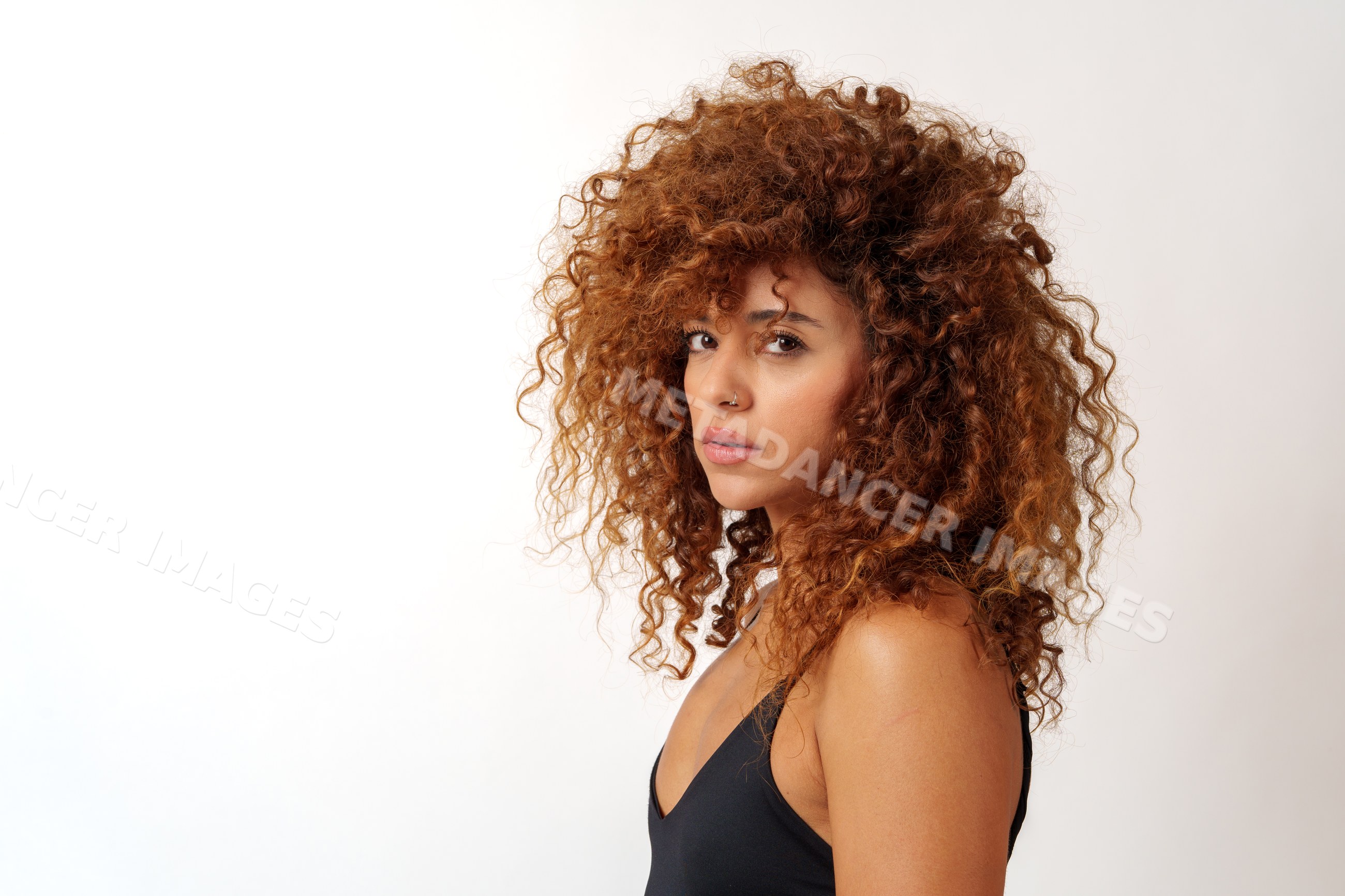 Hispanic woman with voluminous curly red hair and nose ring