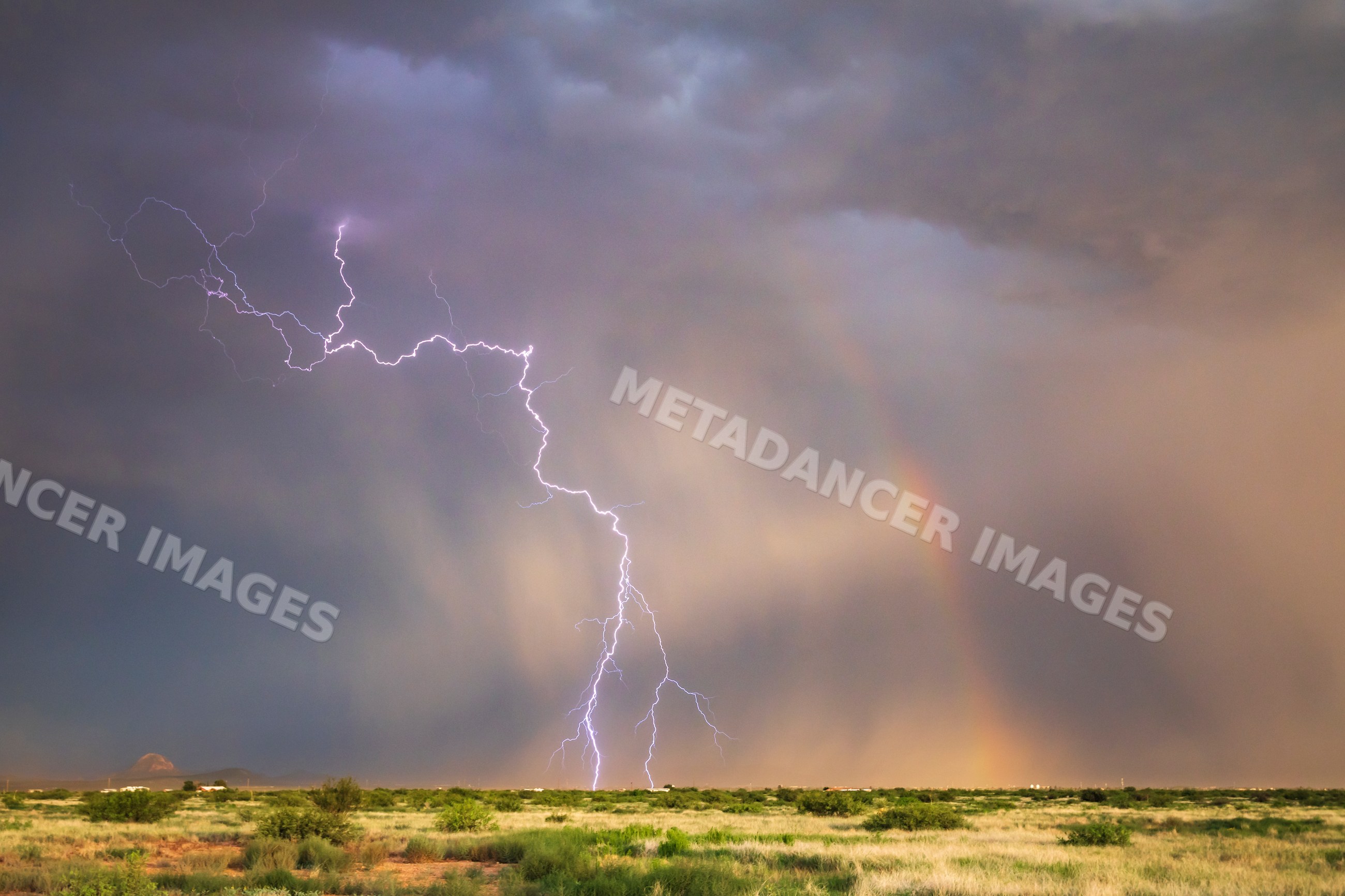 Lightning strike and Rainbow over grassland in douglas, Arizona, USA