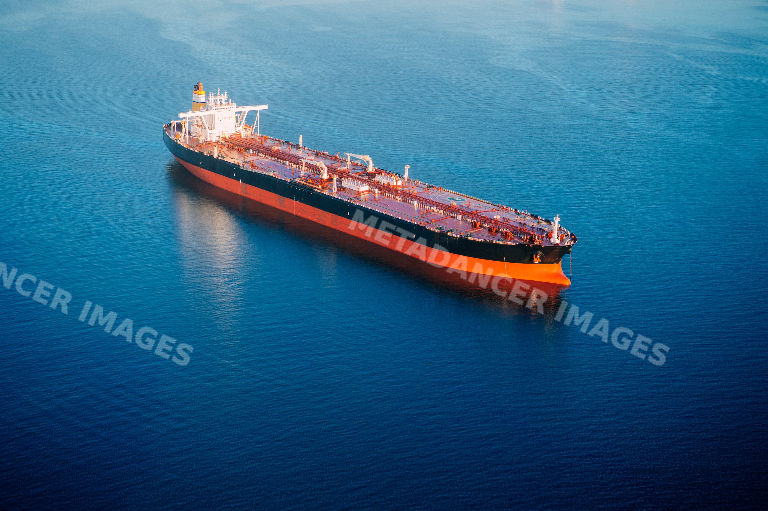 Oil tanker ship anchored in calm ocean in a beach