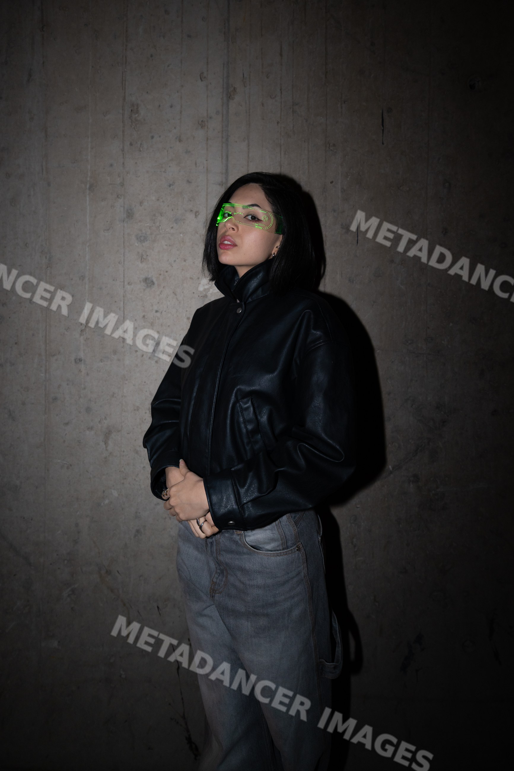 Hispanic woman wearing black leather jacket and green visor glasses