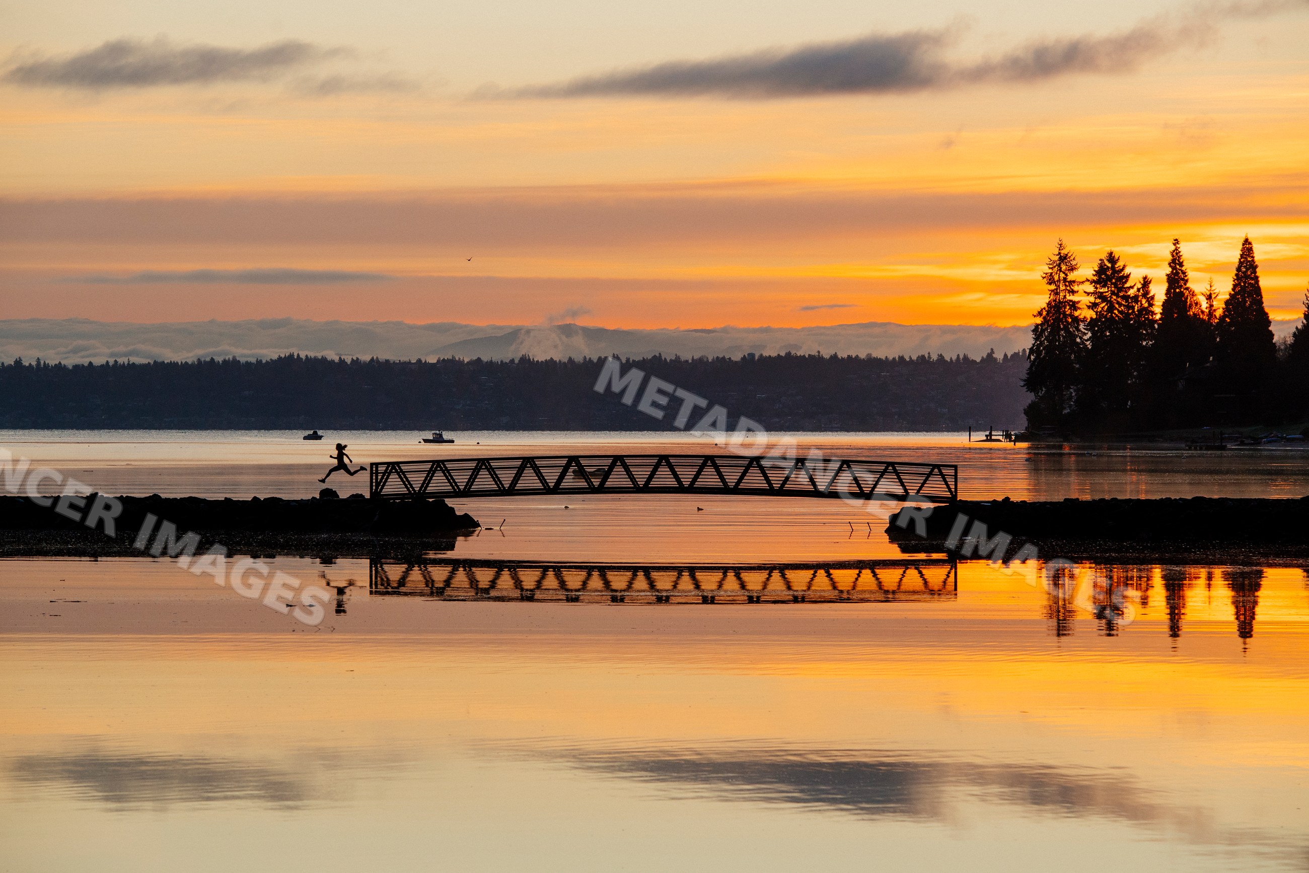 Sunset silhouette of Pacific Islander person jumping across bridge