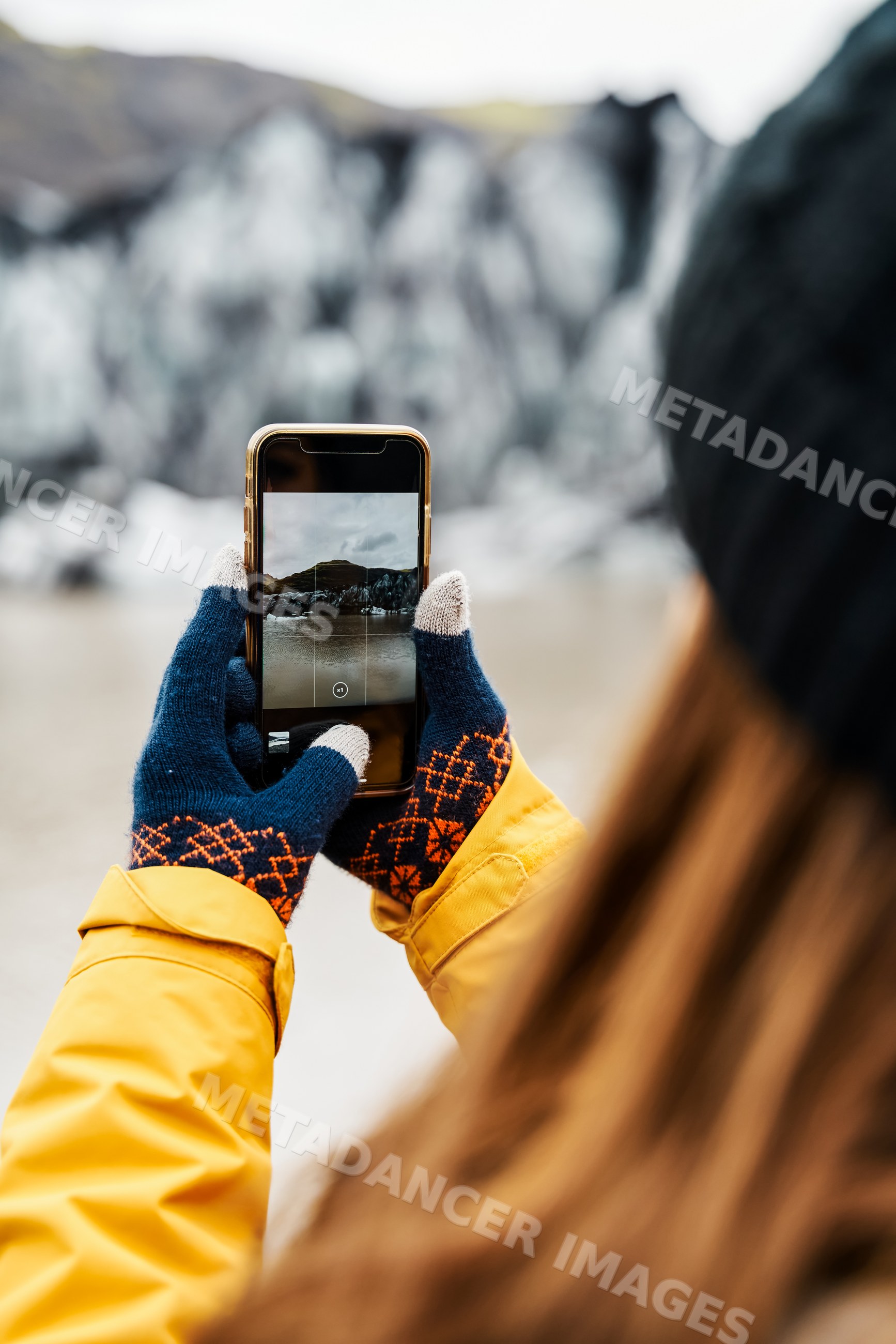 A white person captures a photo of a glacier
