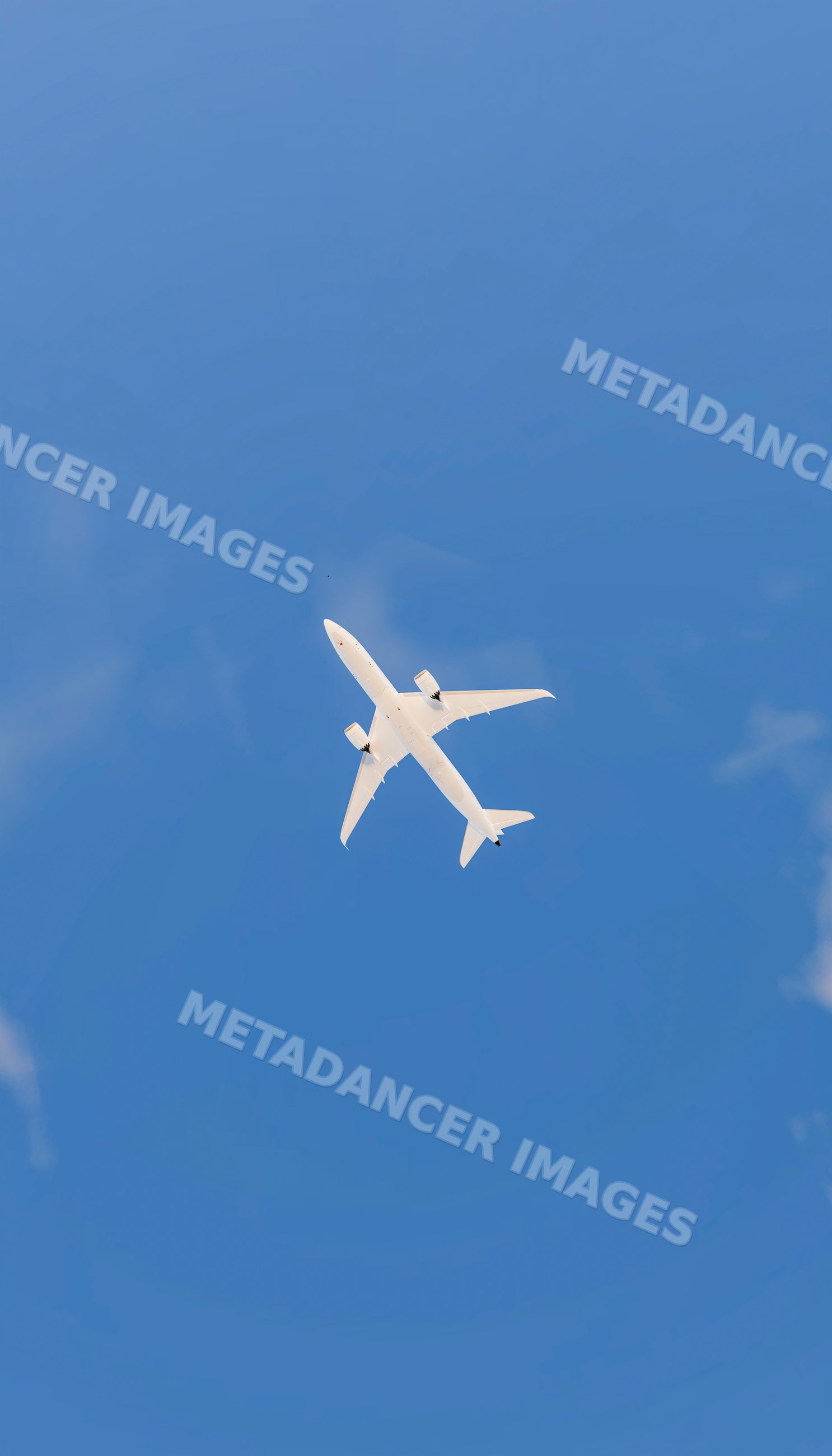 A white commercial airplane flying overhead against a clear blue sky