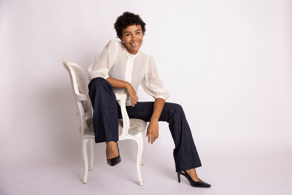 Hispanic woman sitting on antique chair smiling