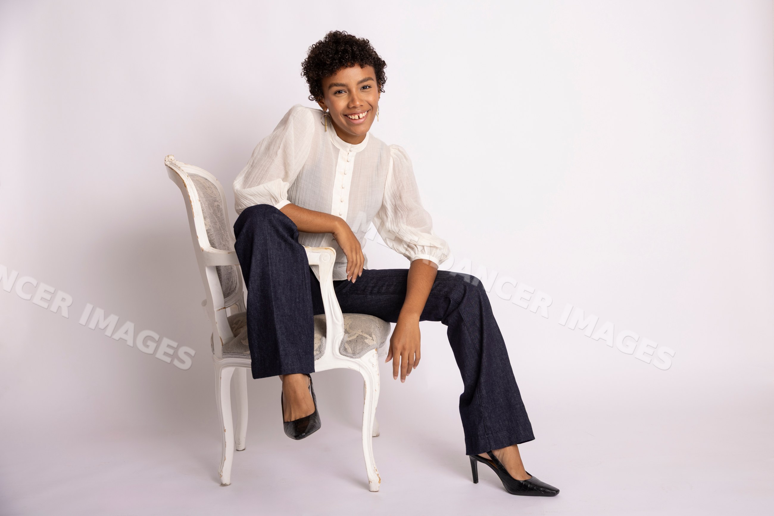 Hispanic woman sitting on antique chair smiling