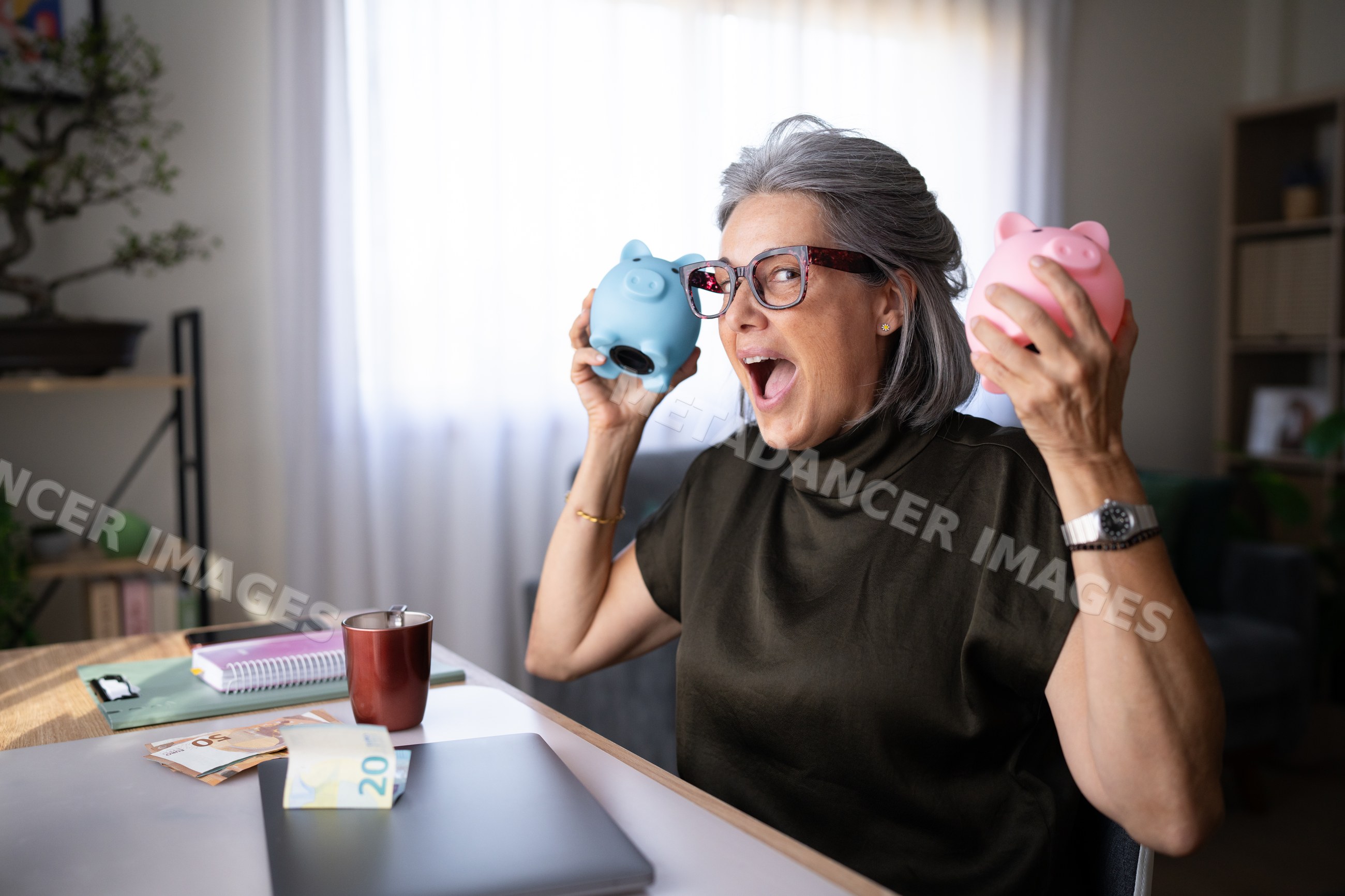 Senior white woman holding piggy banks with euro money