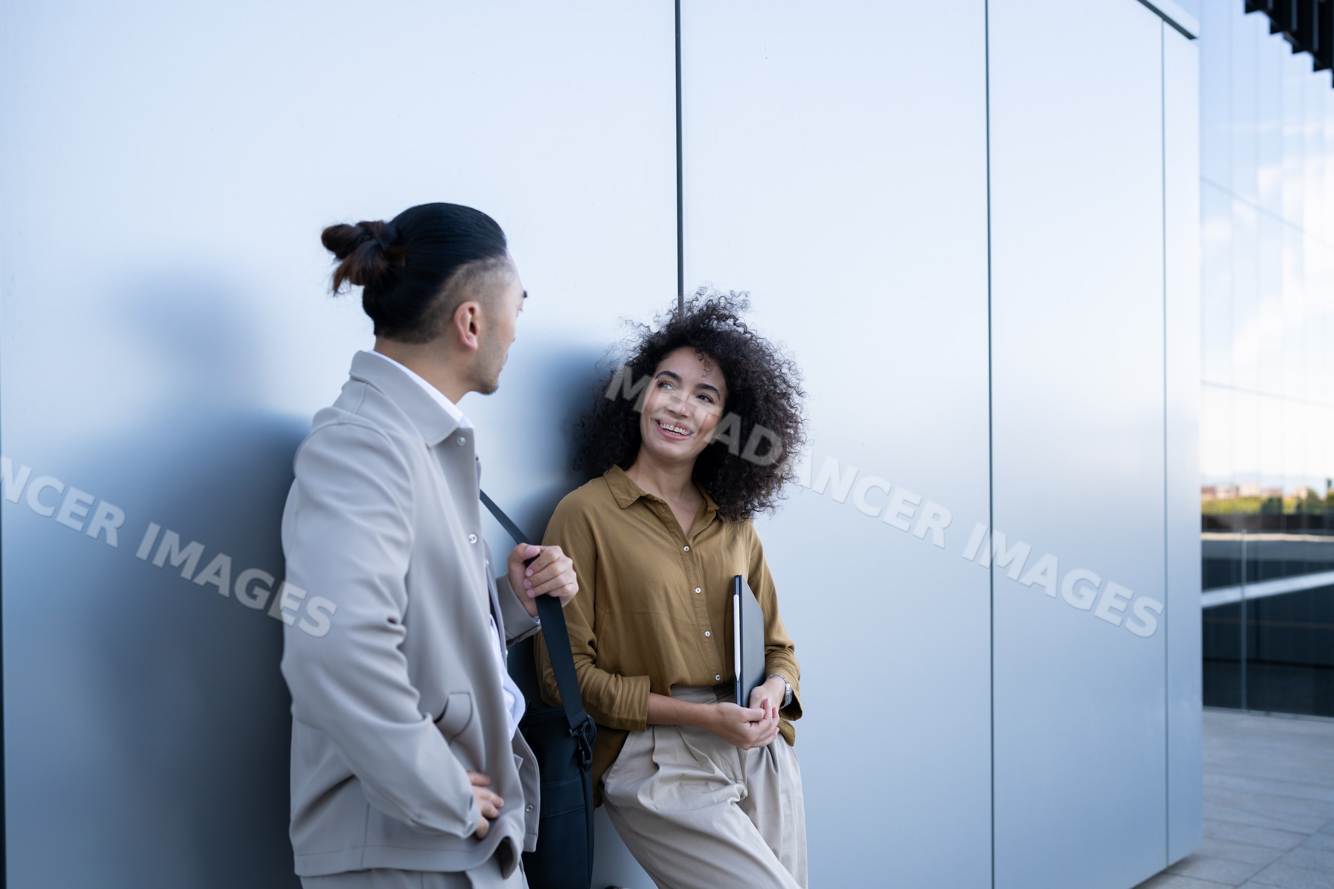 Two people talking outside modern building