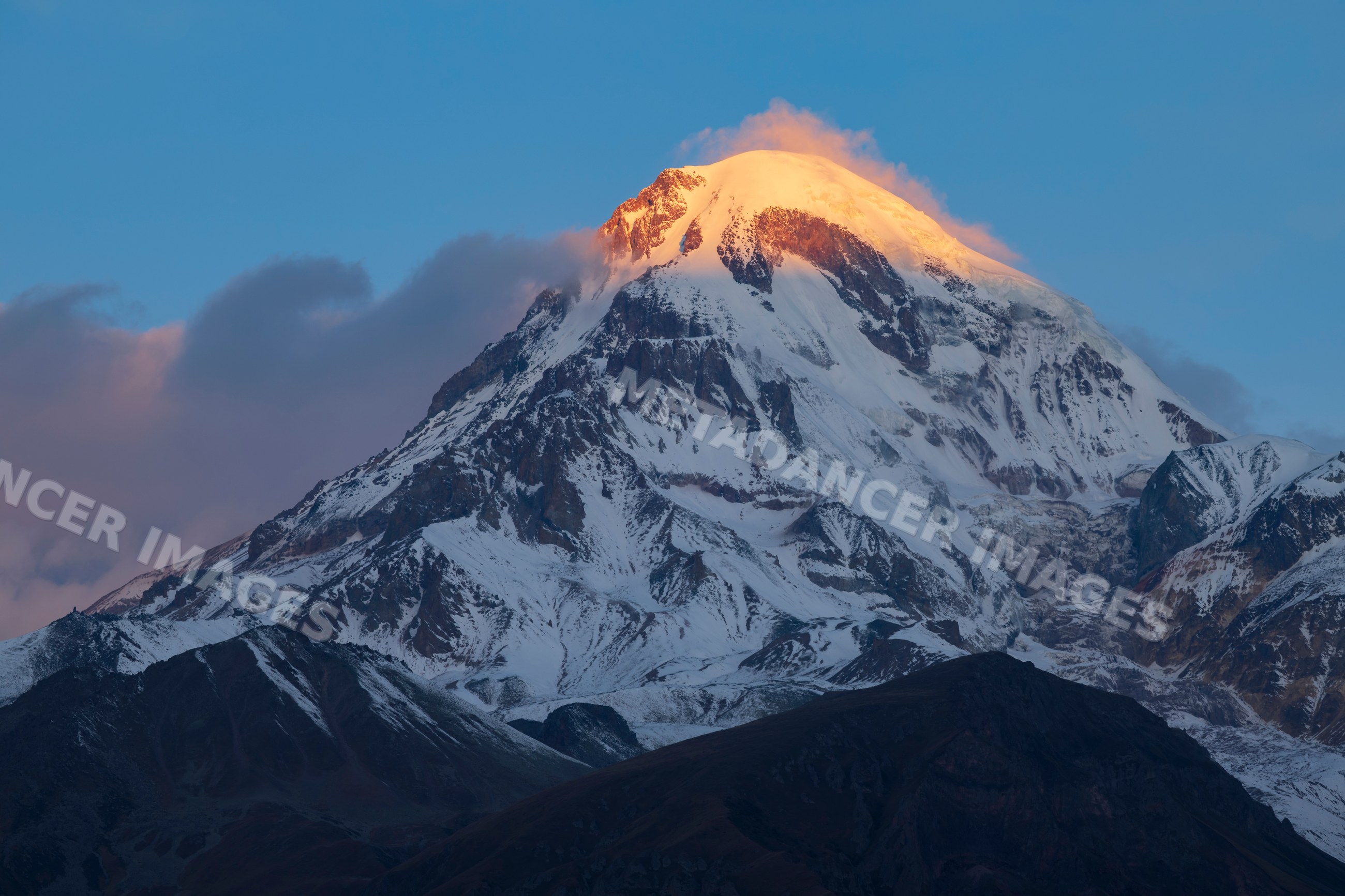 Mt kazbegi Sunrise with glowing snow-capped peak near stepantsminda