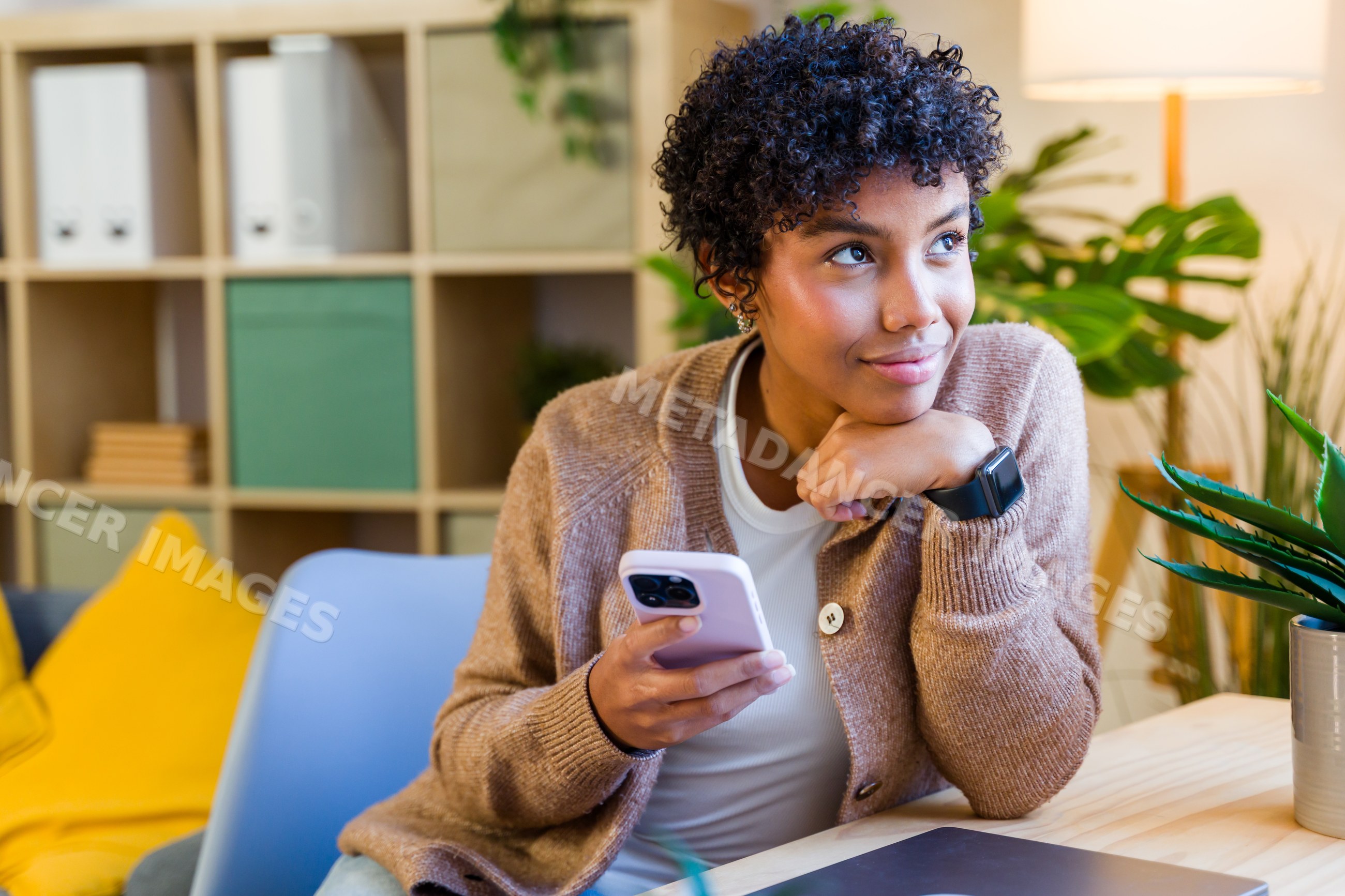African American woman holding phone sitting