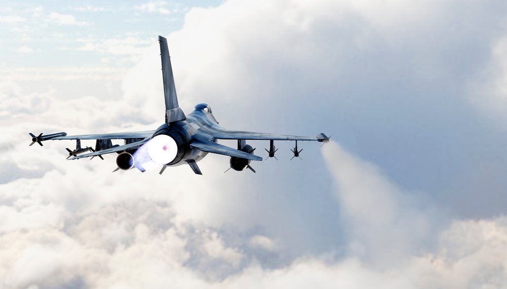 A military jet flies through clouds powered by afterburner