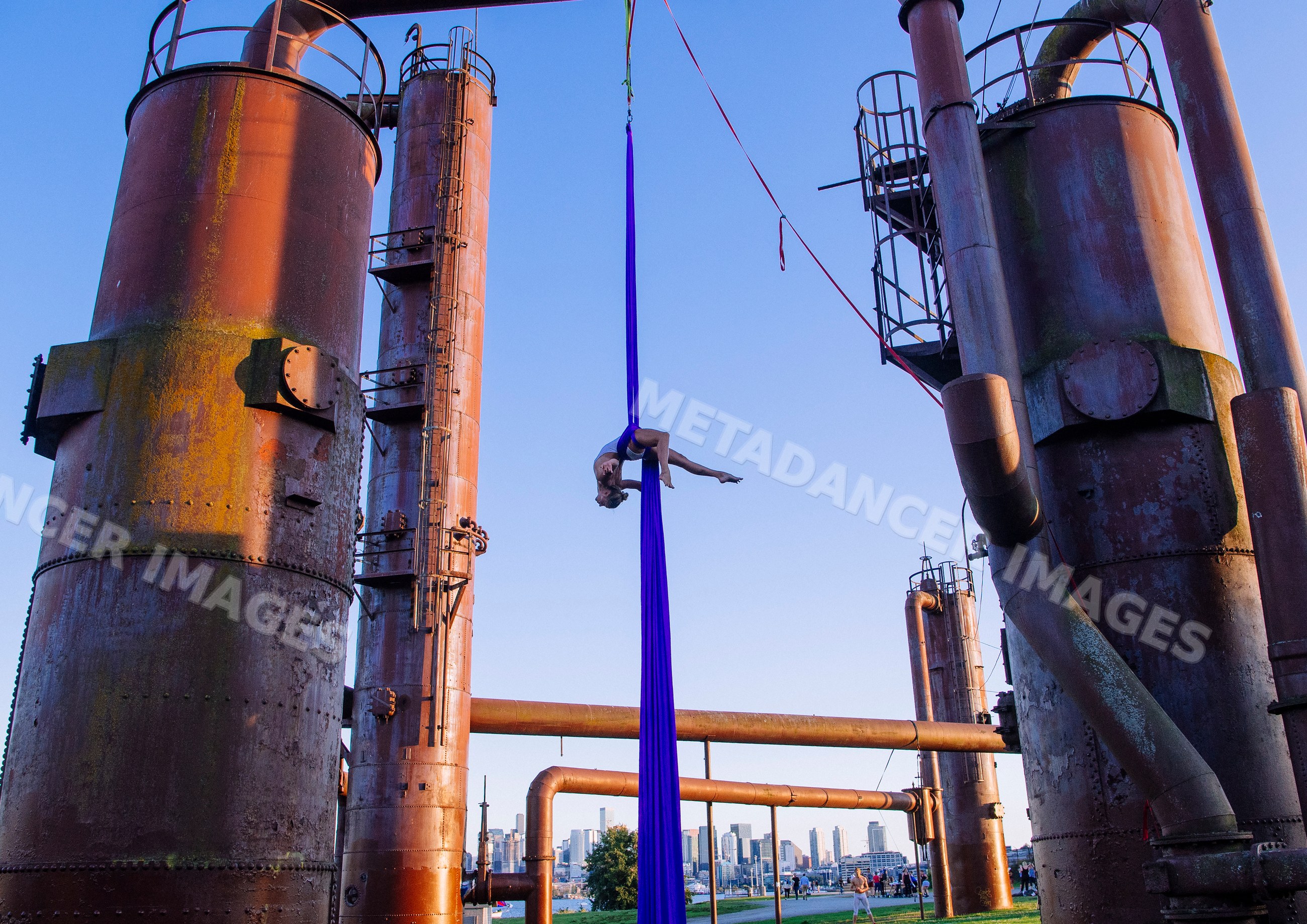 Acrobat performing aerial silks routine outdoors