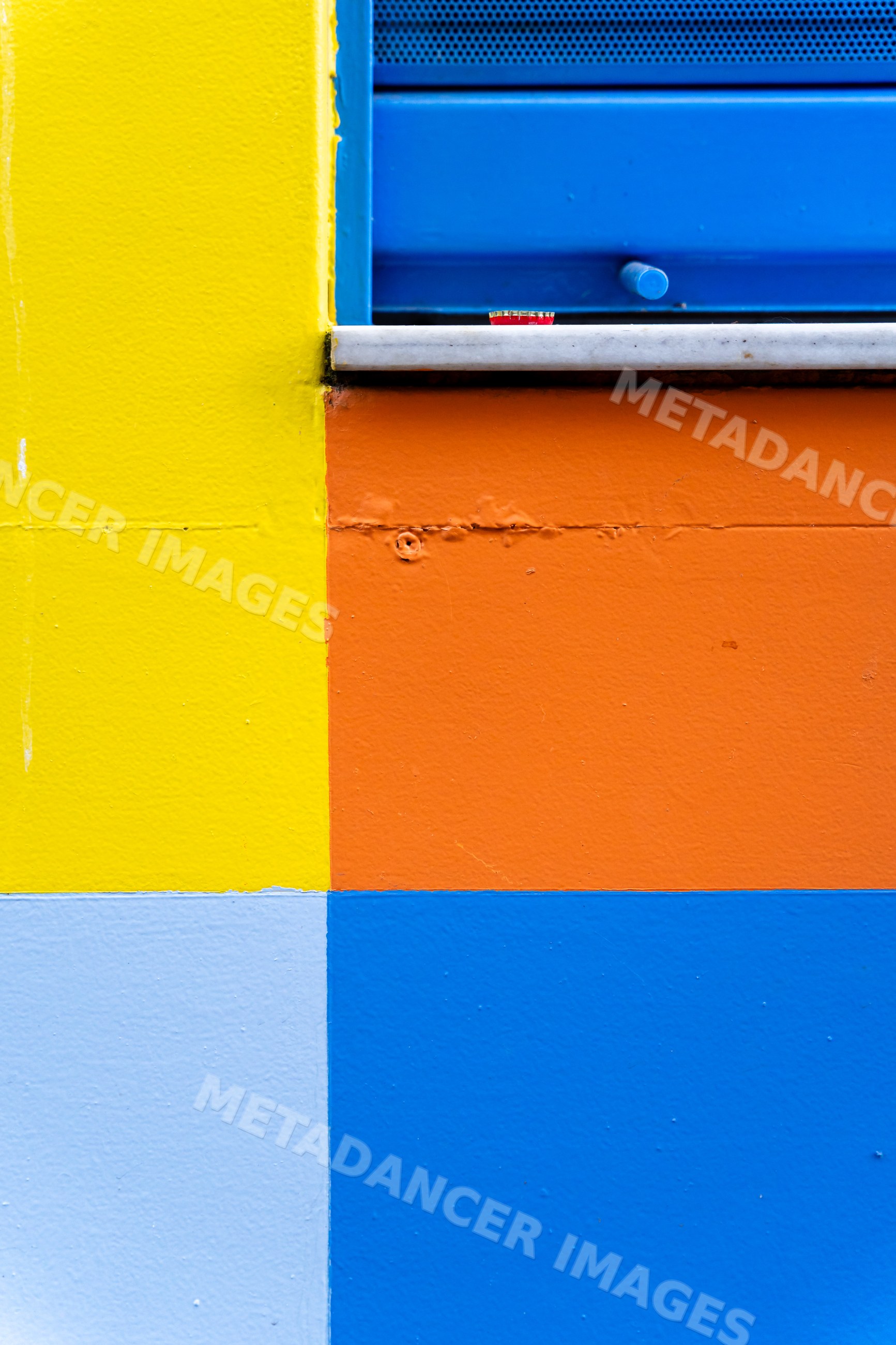 Colorful painted wall with blue window shutter
