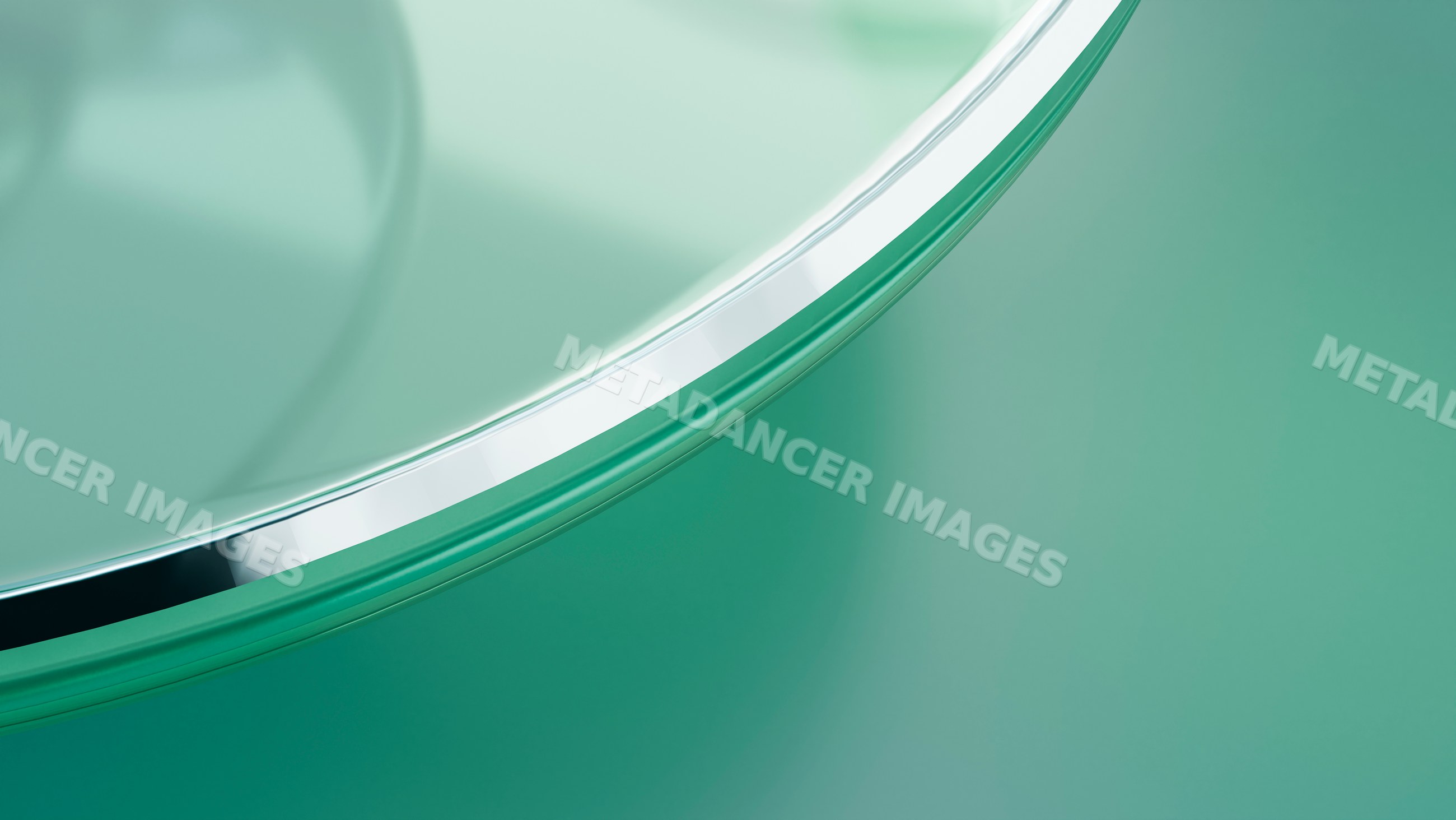 Close-up of glass dish reflecting light on green surface