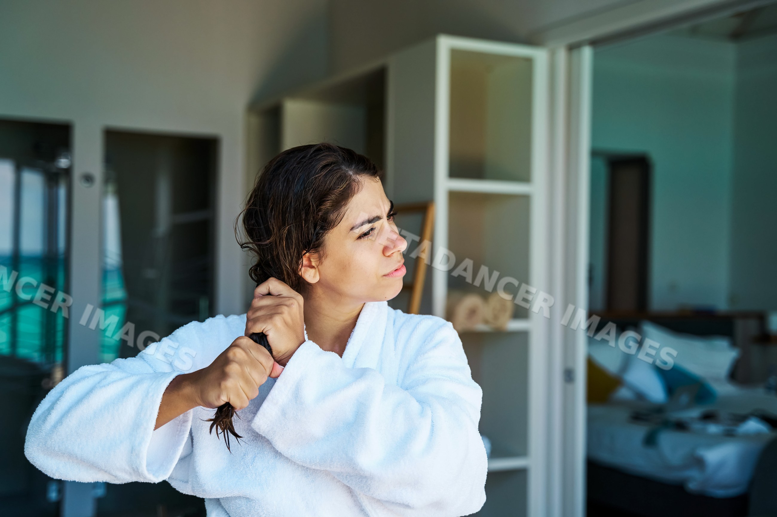 White Woman combing her wet hair in a hotel room in a hotel