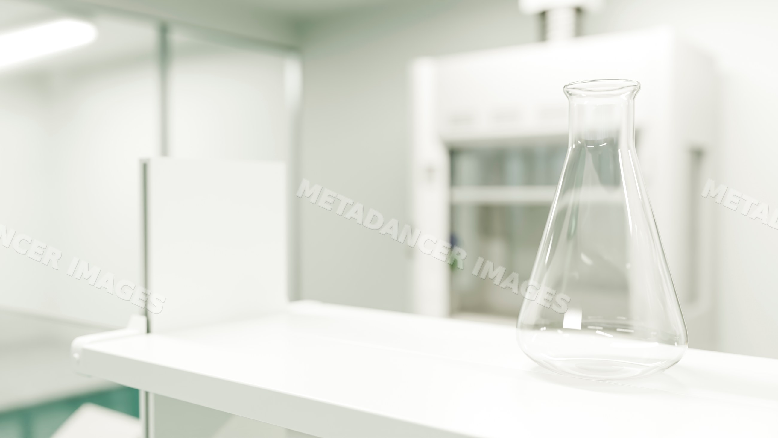 Empty glass flask on white lab shelf in modern chemistry laboratory