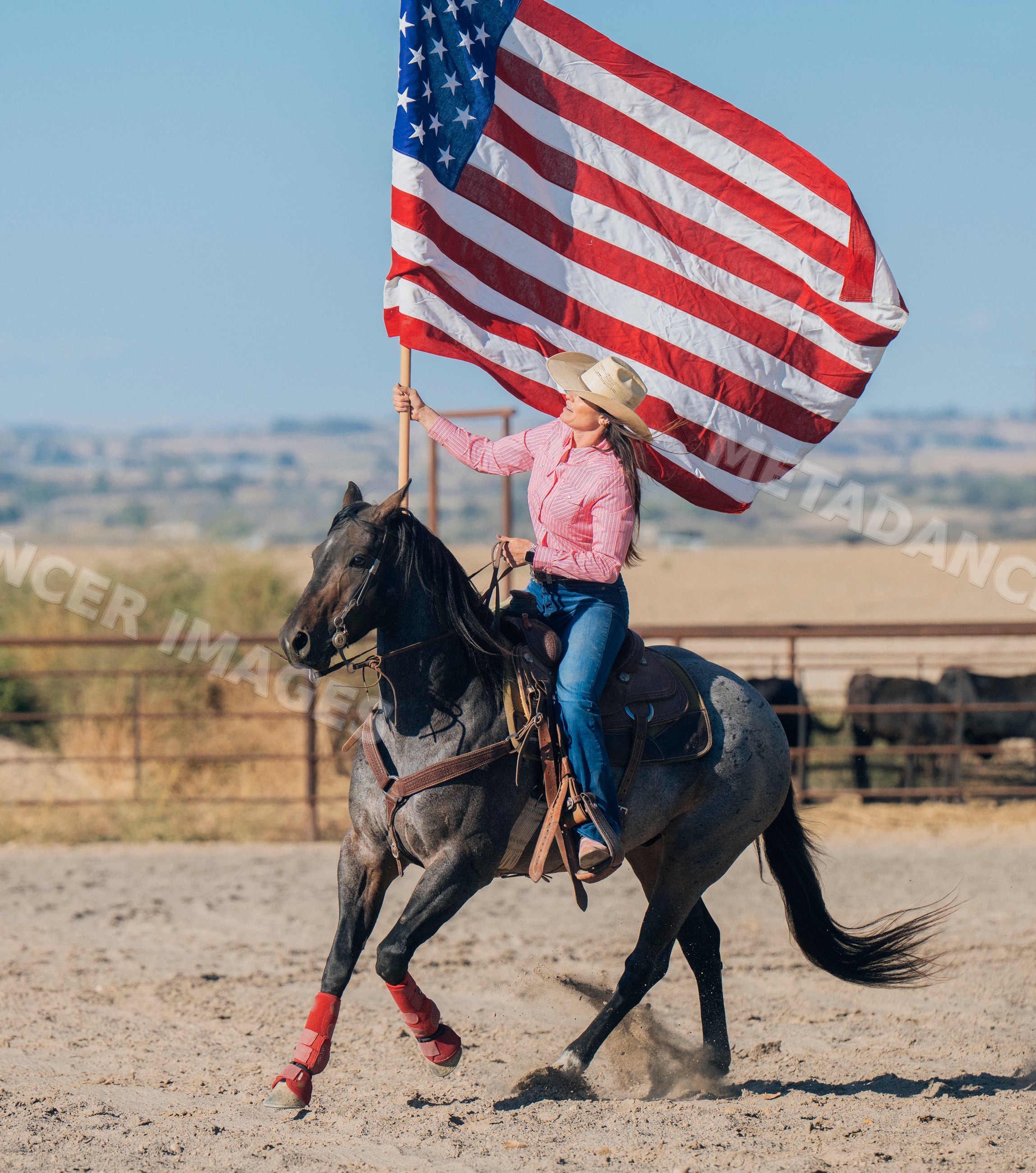 White woman riding horse holding american flag