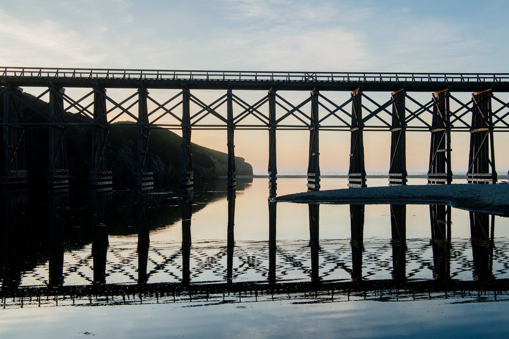 Wooden bridge reflecting over water at sunset California USA