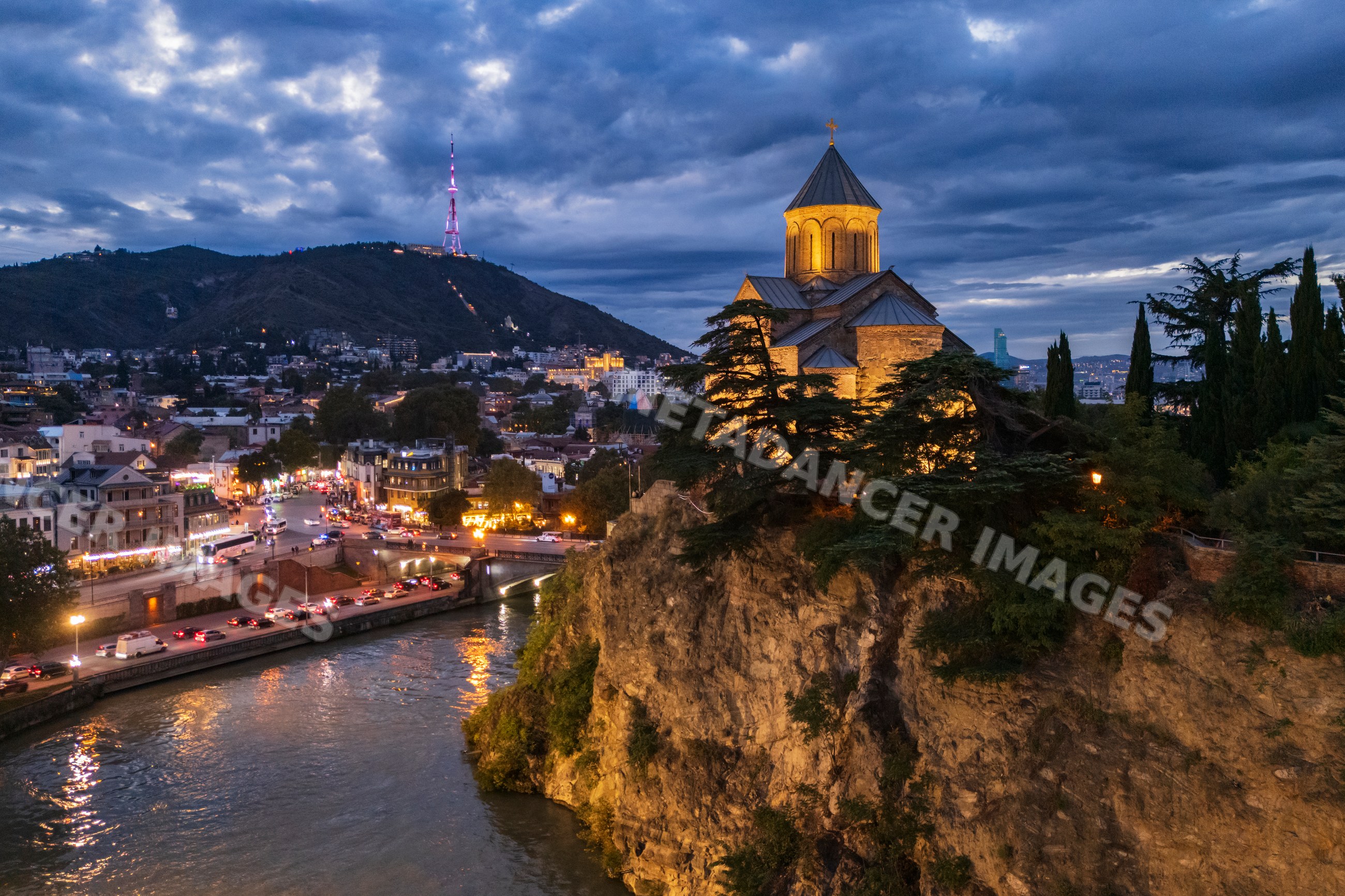 Metekhi Church illuminated on cliff at Dusk in tbilisi Georgia