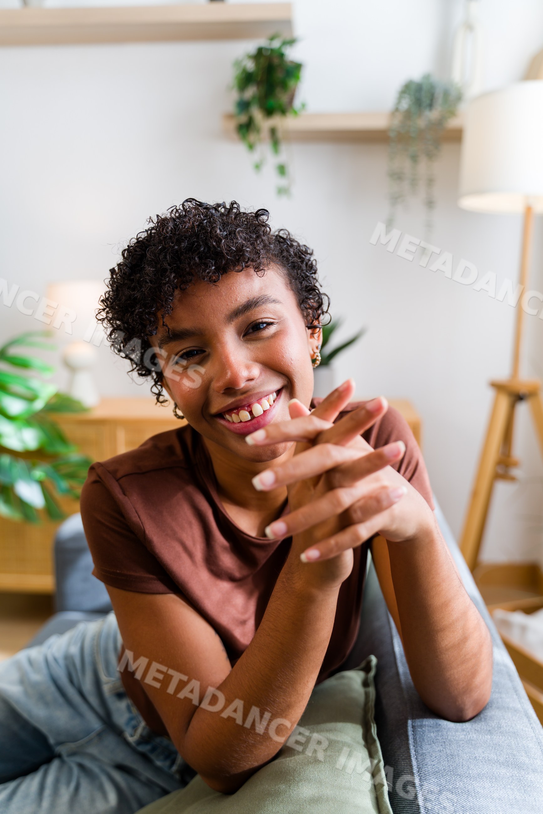 African American woman smiling and sitting on couch in living room