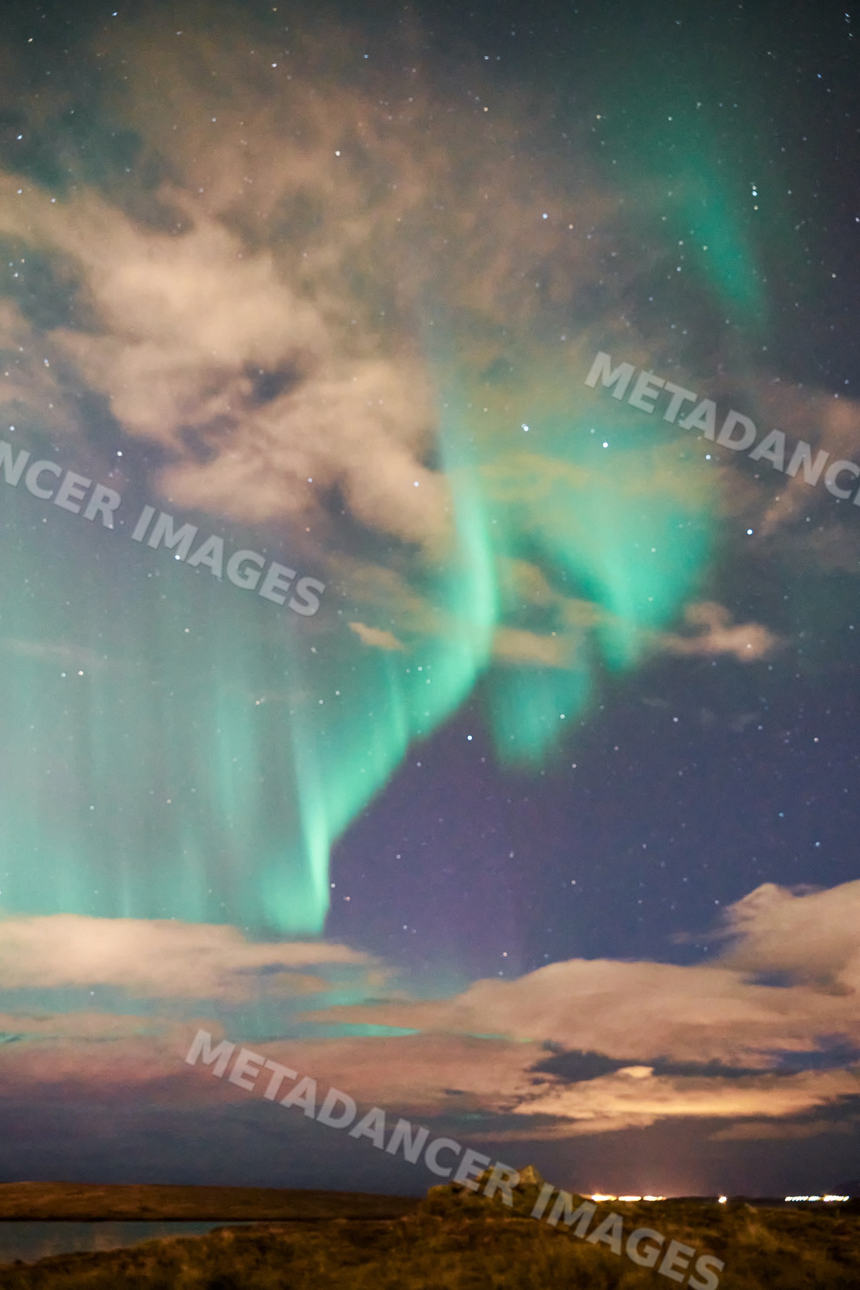 The northern lights illuminate the night sky over the landscape