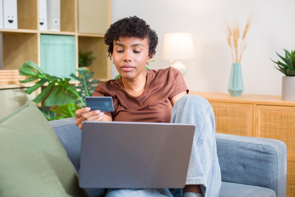 Young African American woman shopping online with credit card using