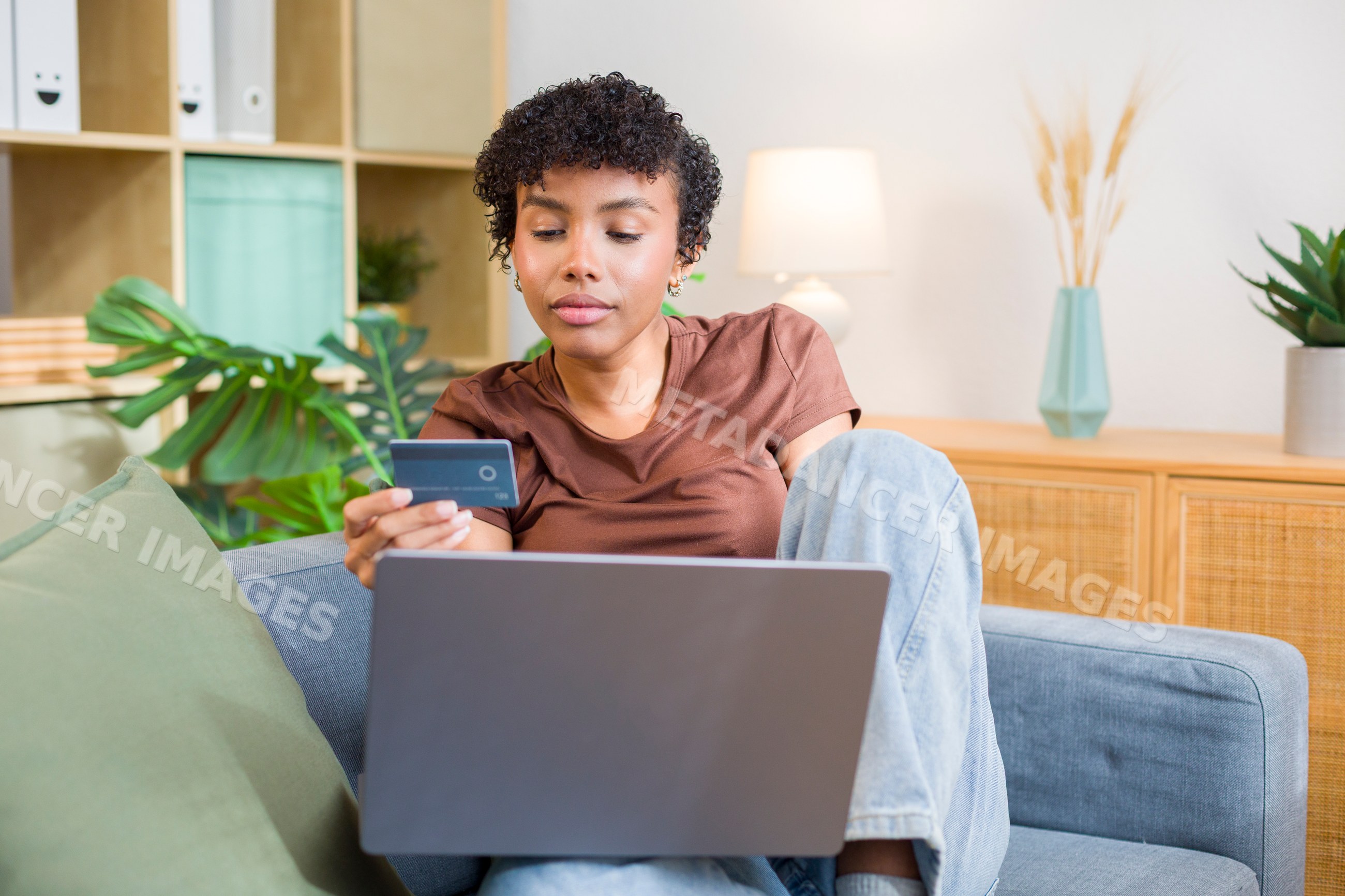 Young African American woman shopping online with credit card using