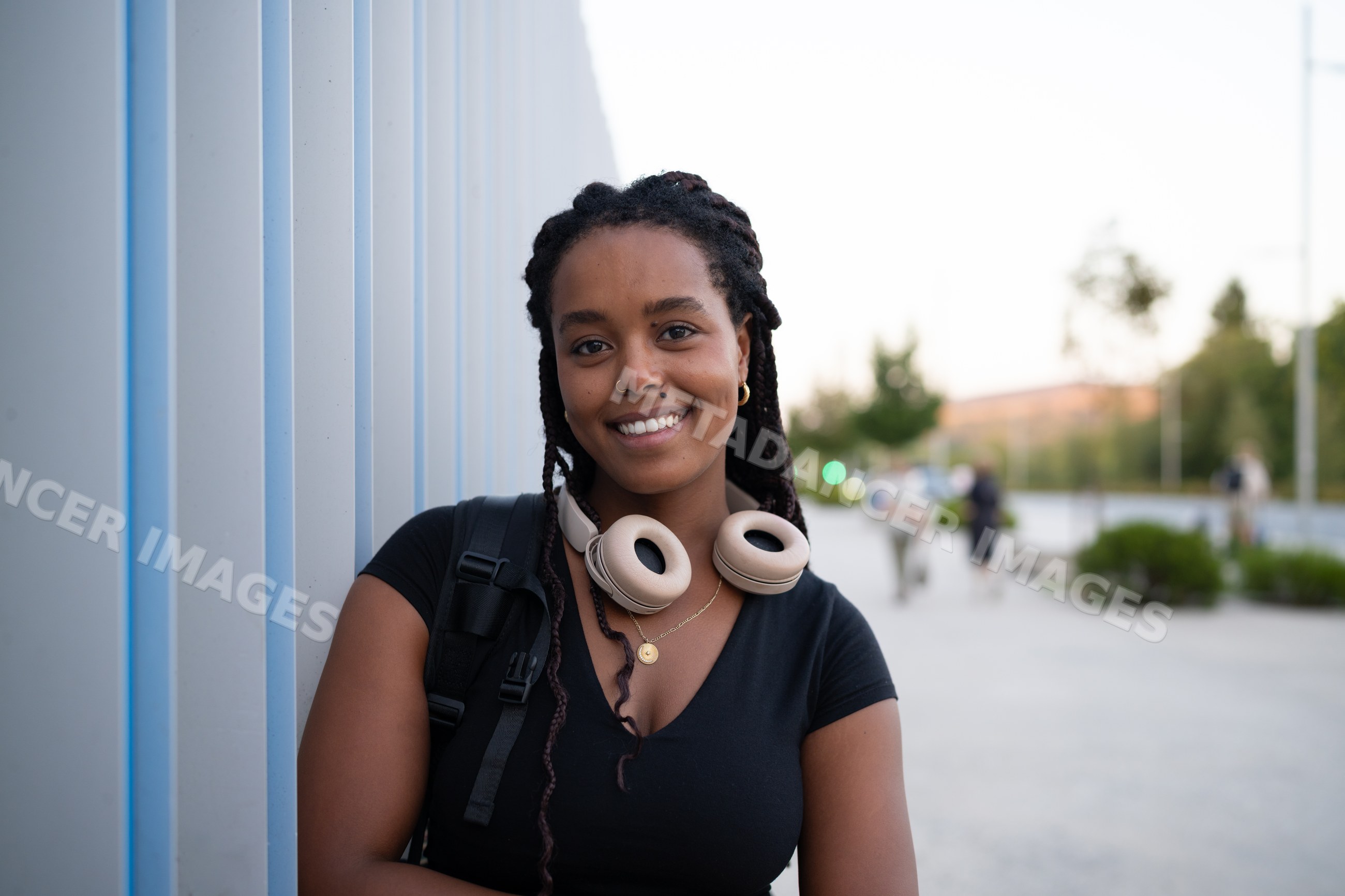 A young African American woman with headphones smiles