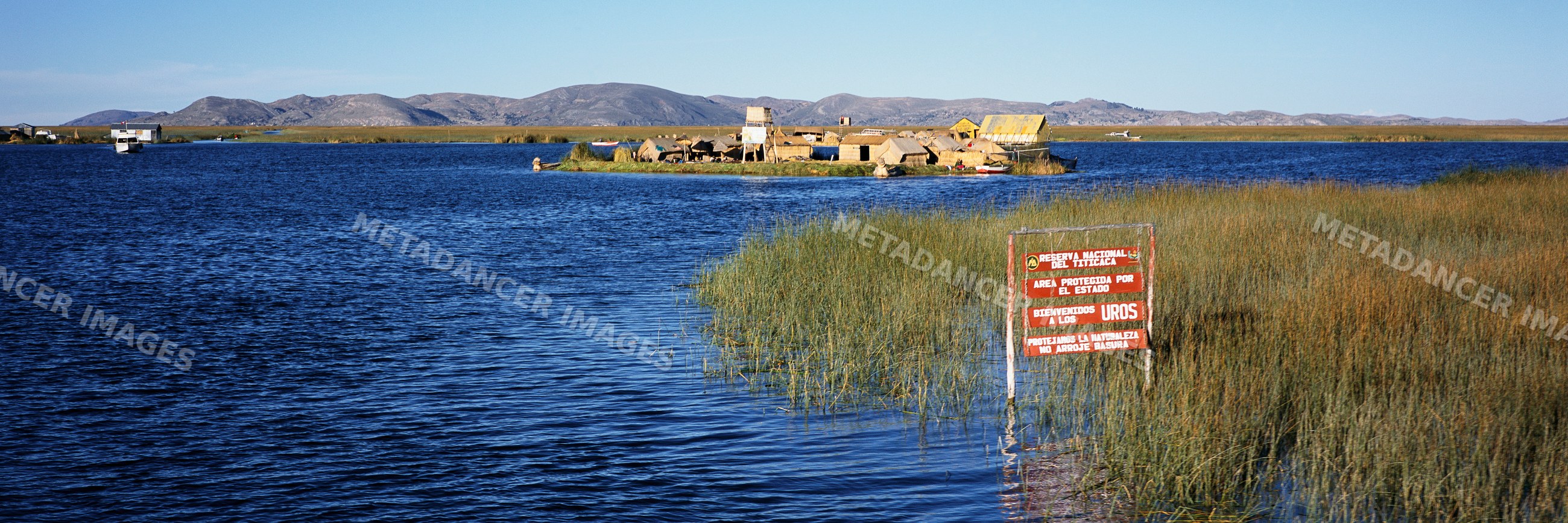 Uros floating islands on lake titicaca with reed homes and mountain