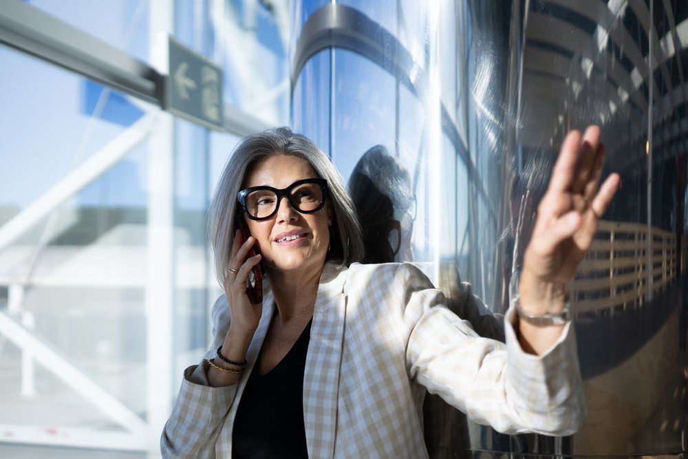 Businesswoman talking on phone near modern building in Madrid