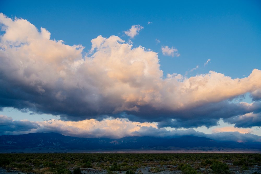 Clouds over Nevada mountain range and shrubland landscape at sunset