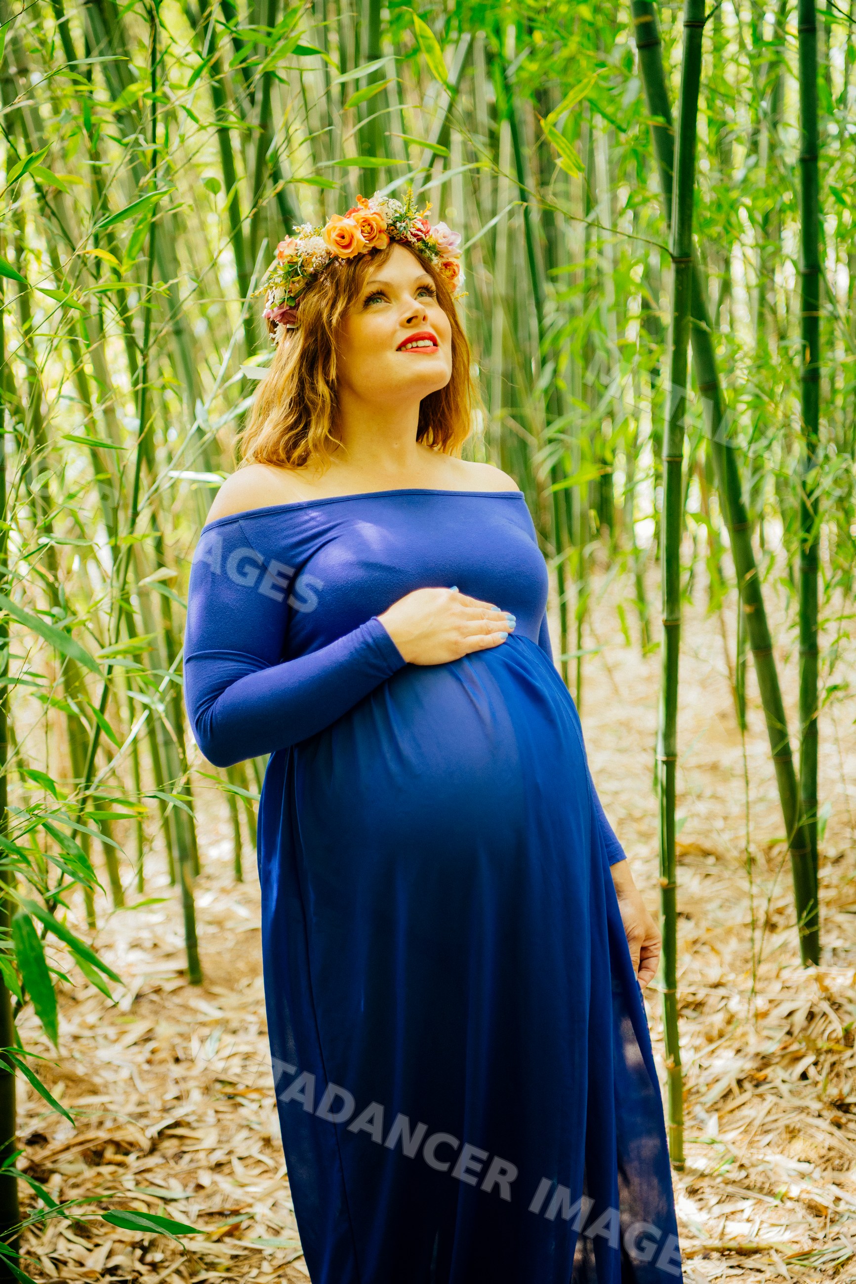 Pregnant white woman in blue dress with floral crown