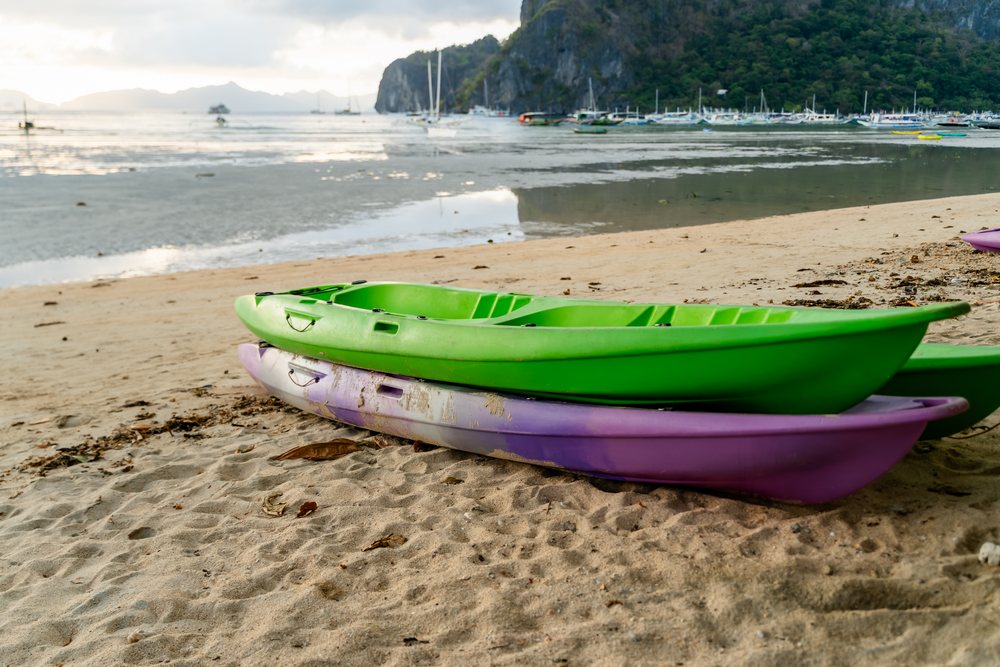 Two kayaks on sandy beach by coastal waters in a beach