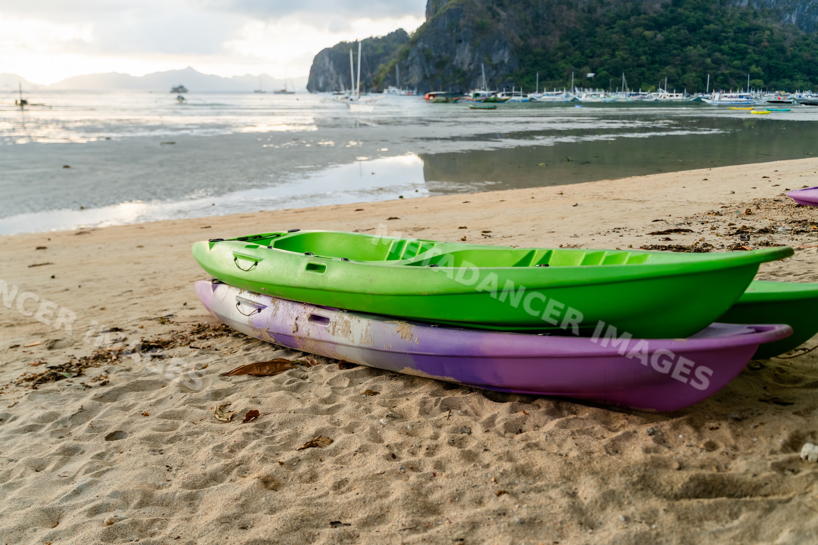 Two kayaks on sandy beach by coastal waters in a beach