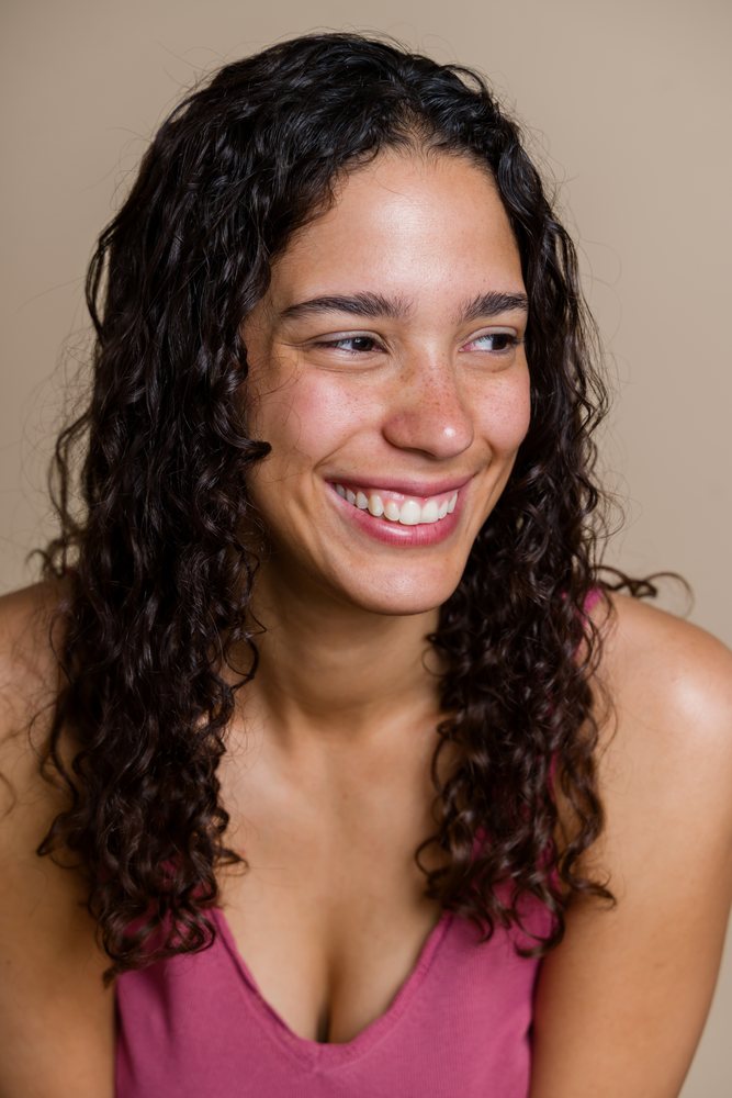 Smiling Hispanic woman with curly hair in beauty studio