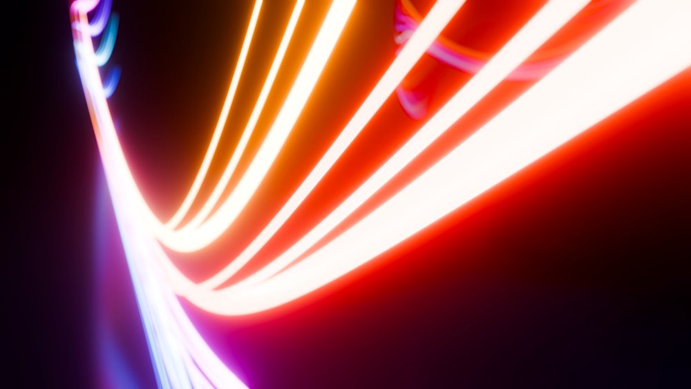 Curved glowing light trails against dark background digital abstract