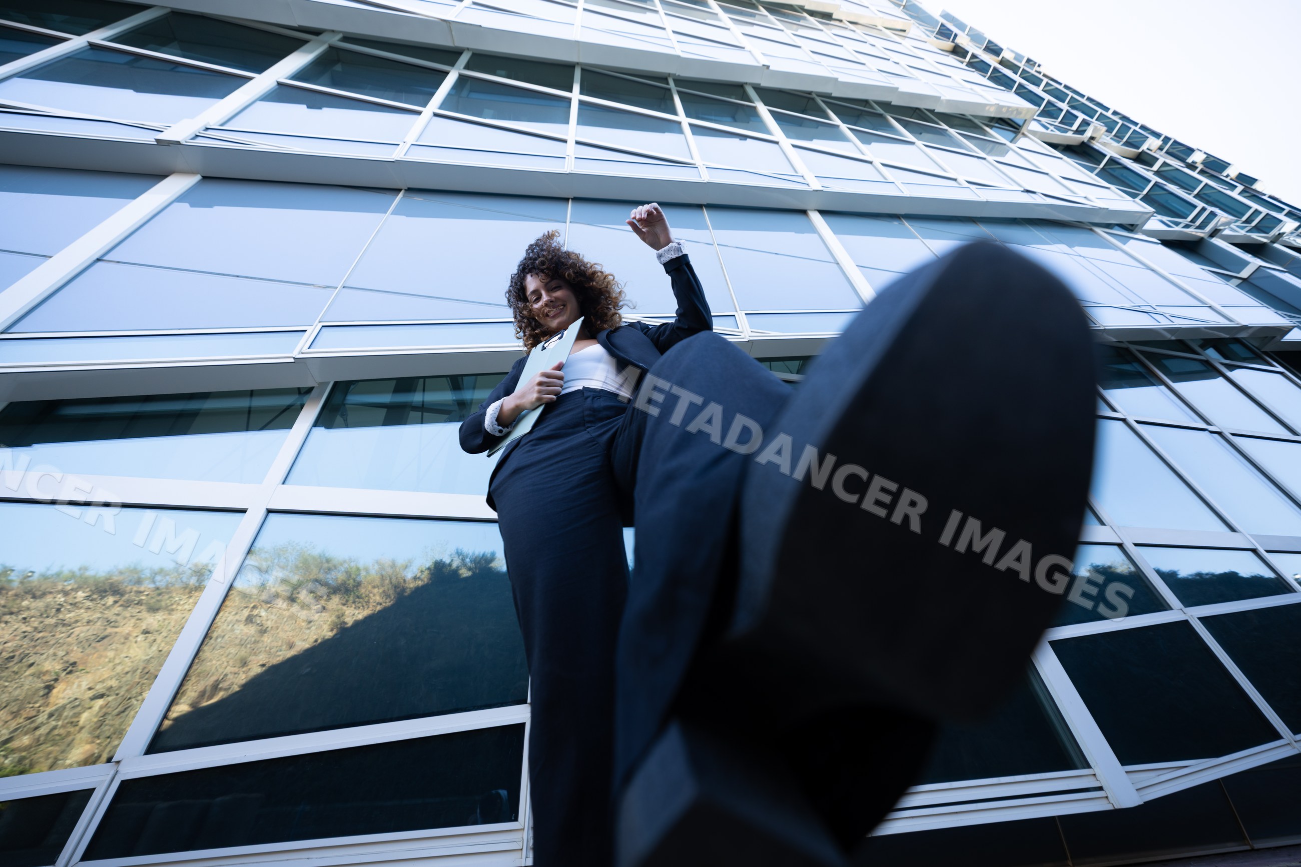 Businesswoman stepping forward in front of glass office building