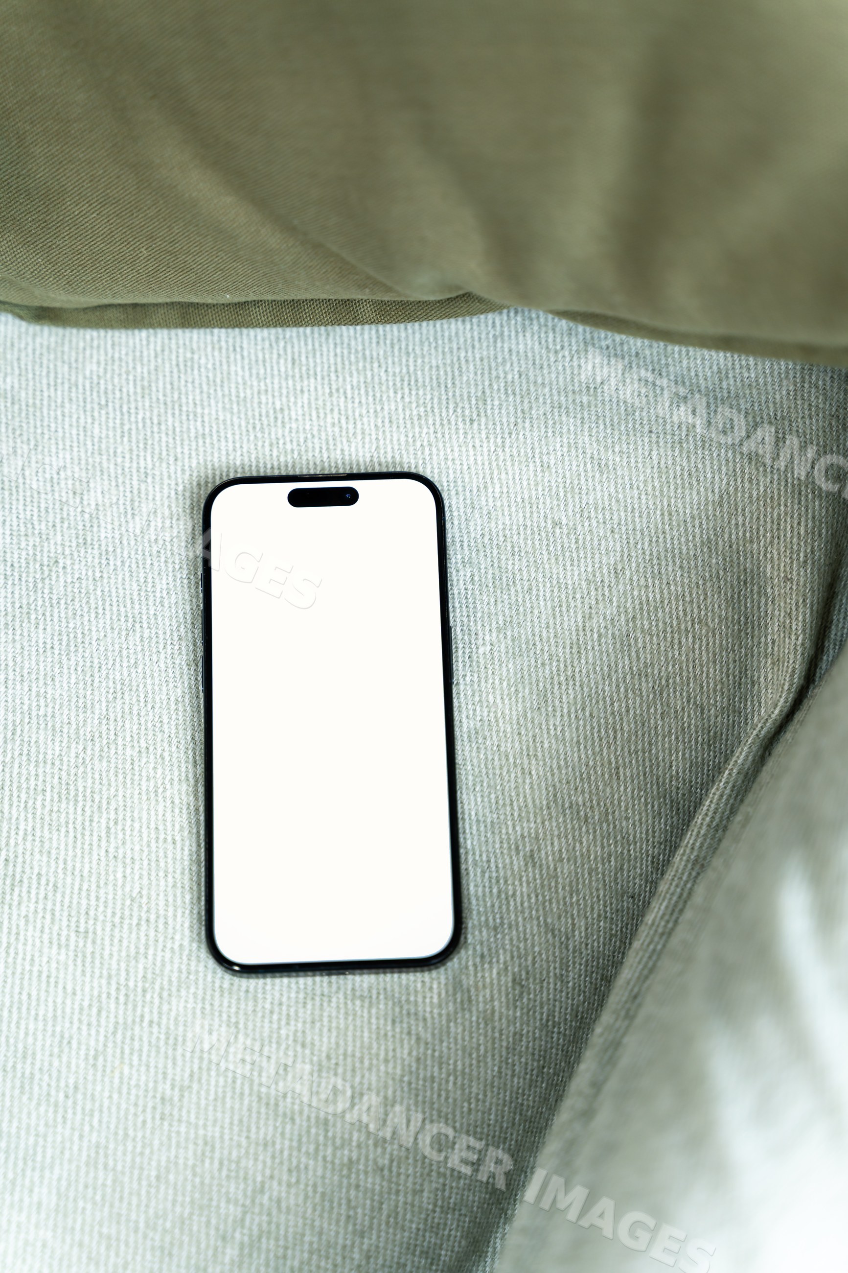 Smartphone with blank white screen on green fabric surface