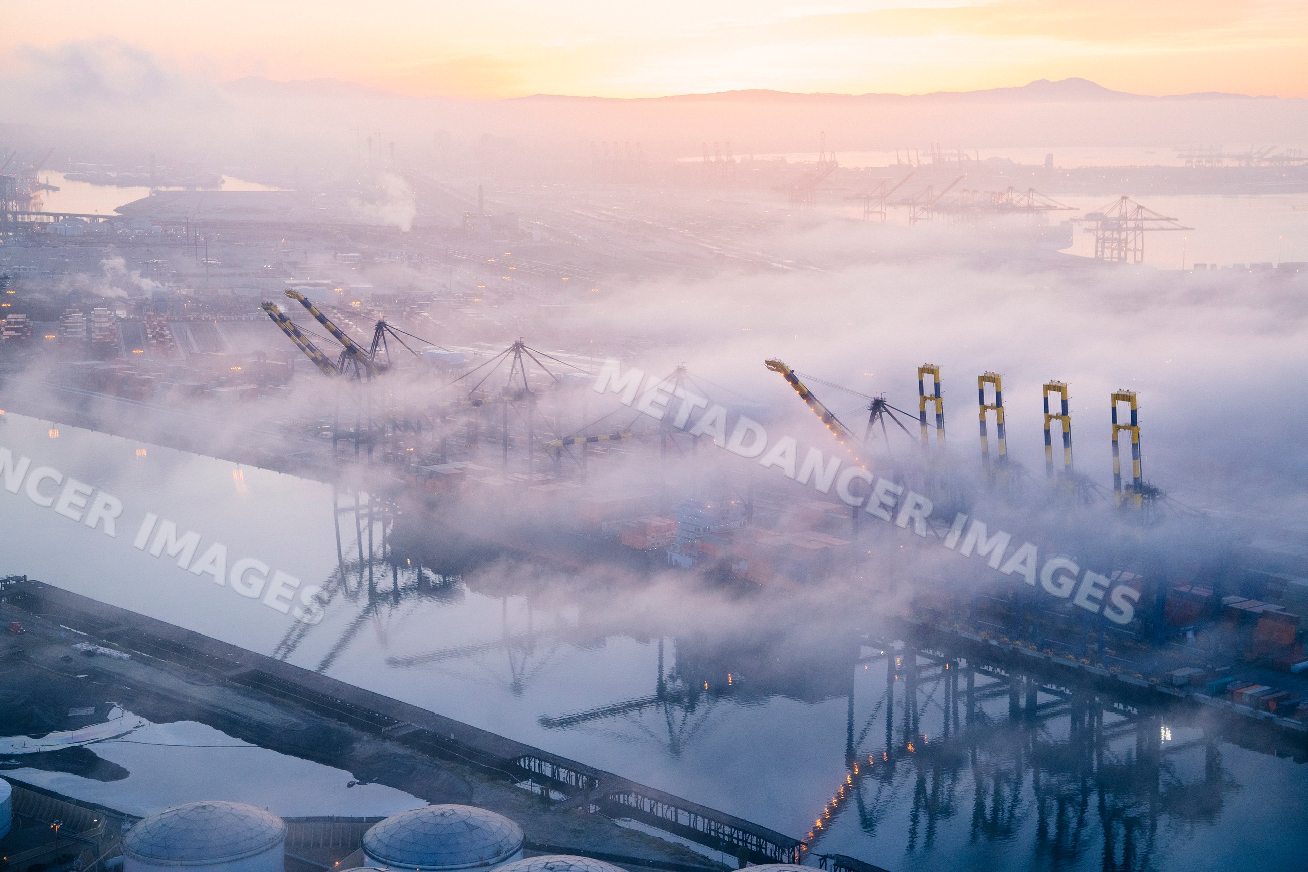 A foggy morning at the container terminal with cranes and ships