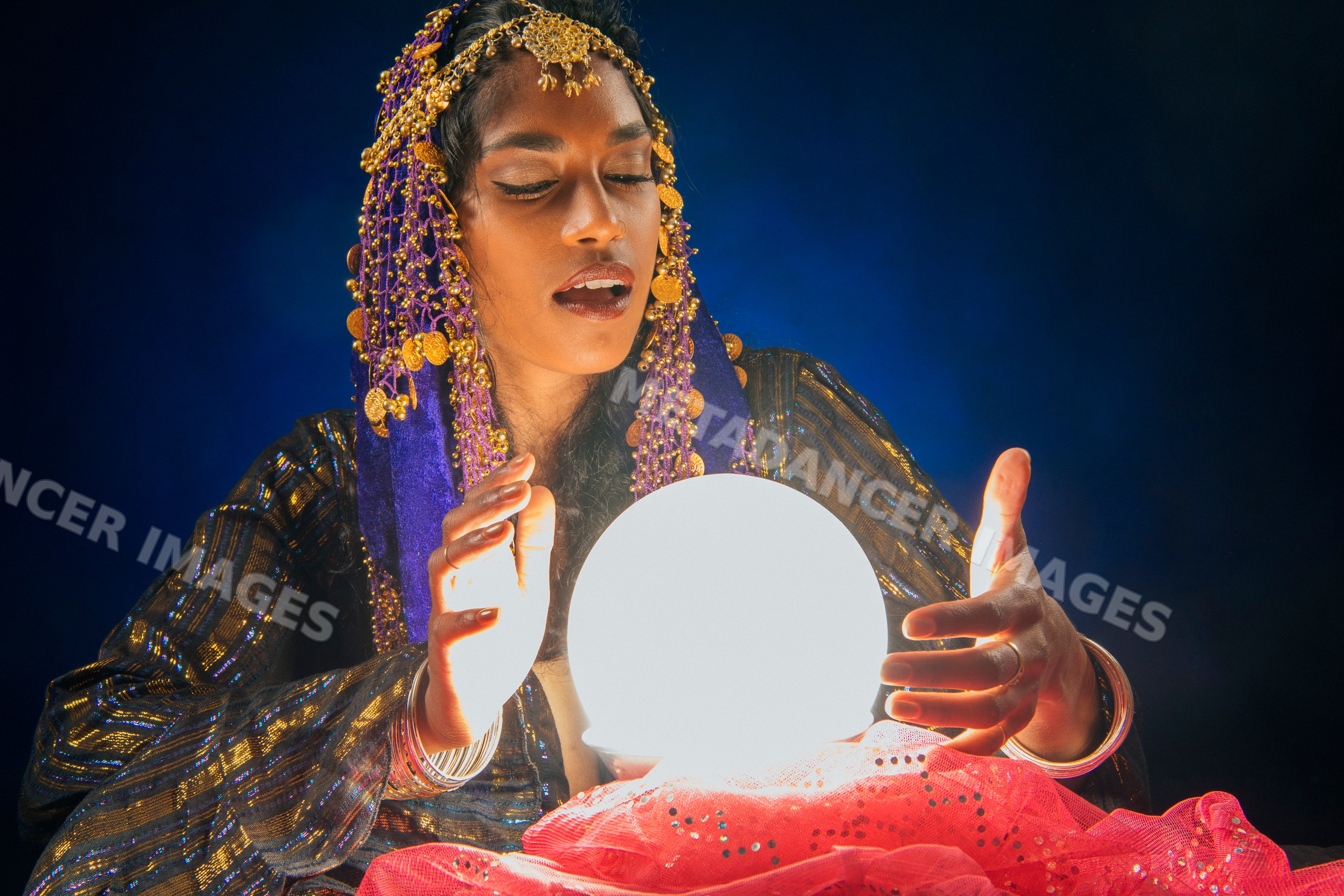 A fortune teller examining a glowing crystal ball