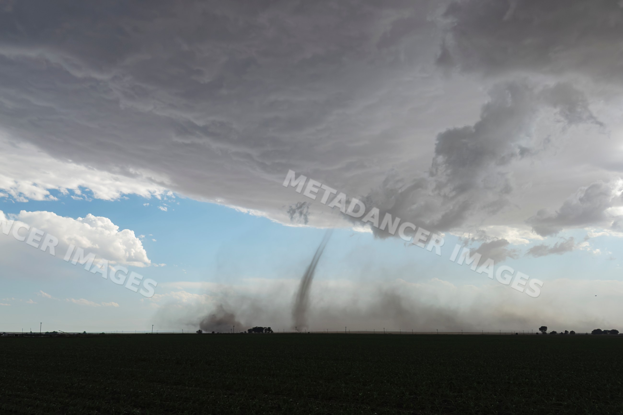 Twin Landspout tornadoes under storm clouds near fowler, colorado