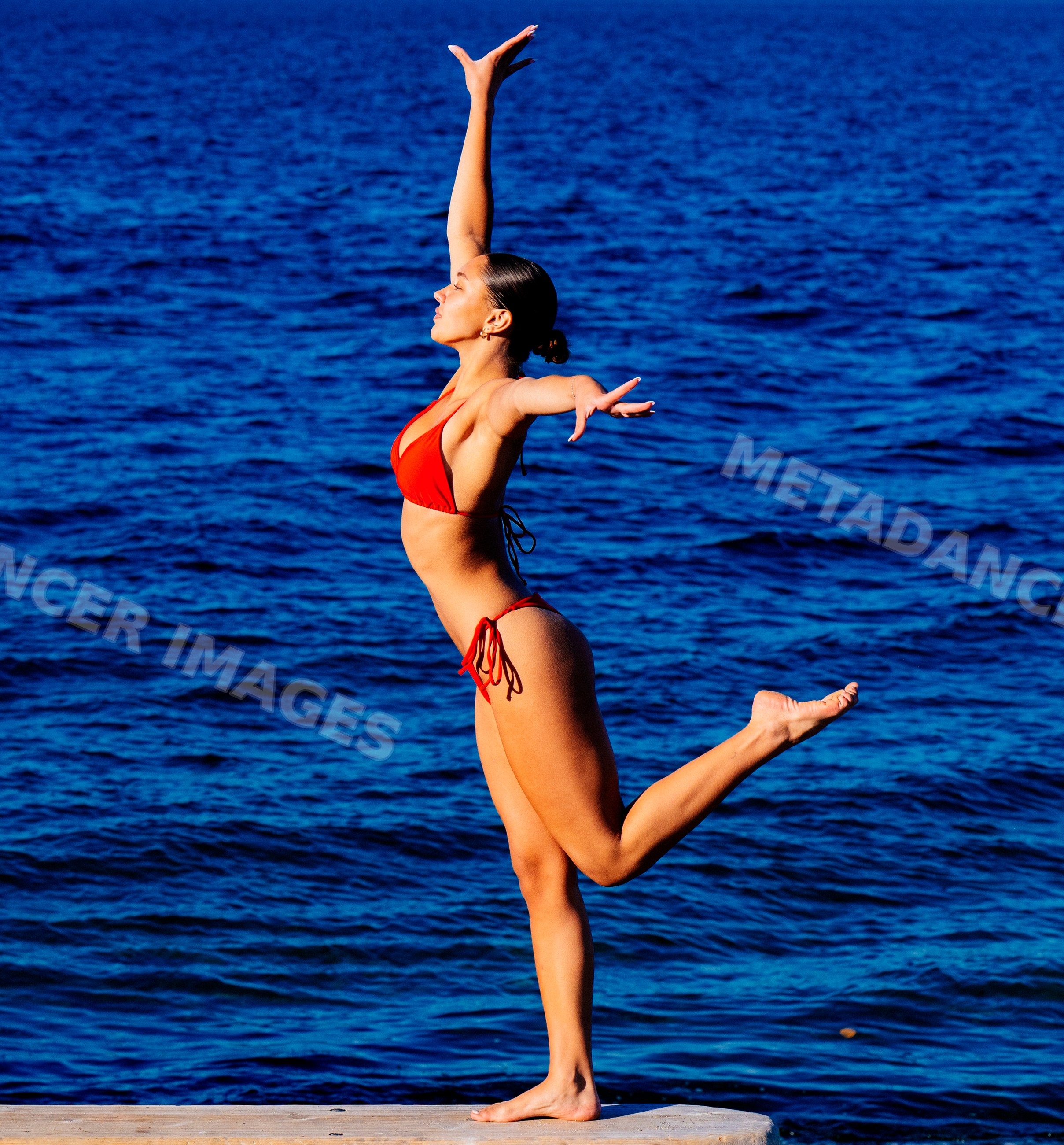 Woman balancing on one leg near lake in washington, USA